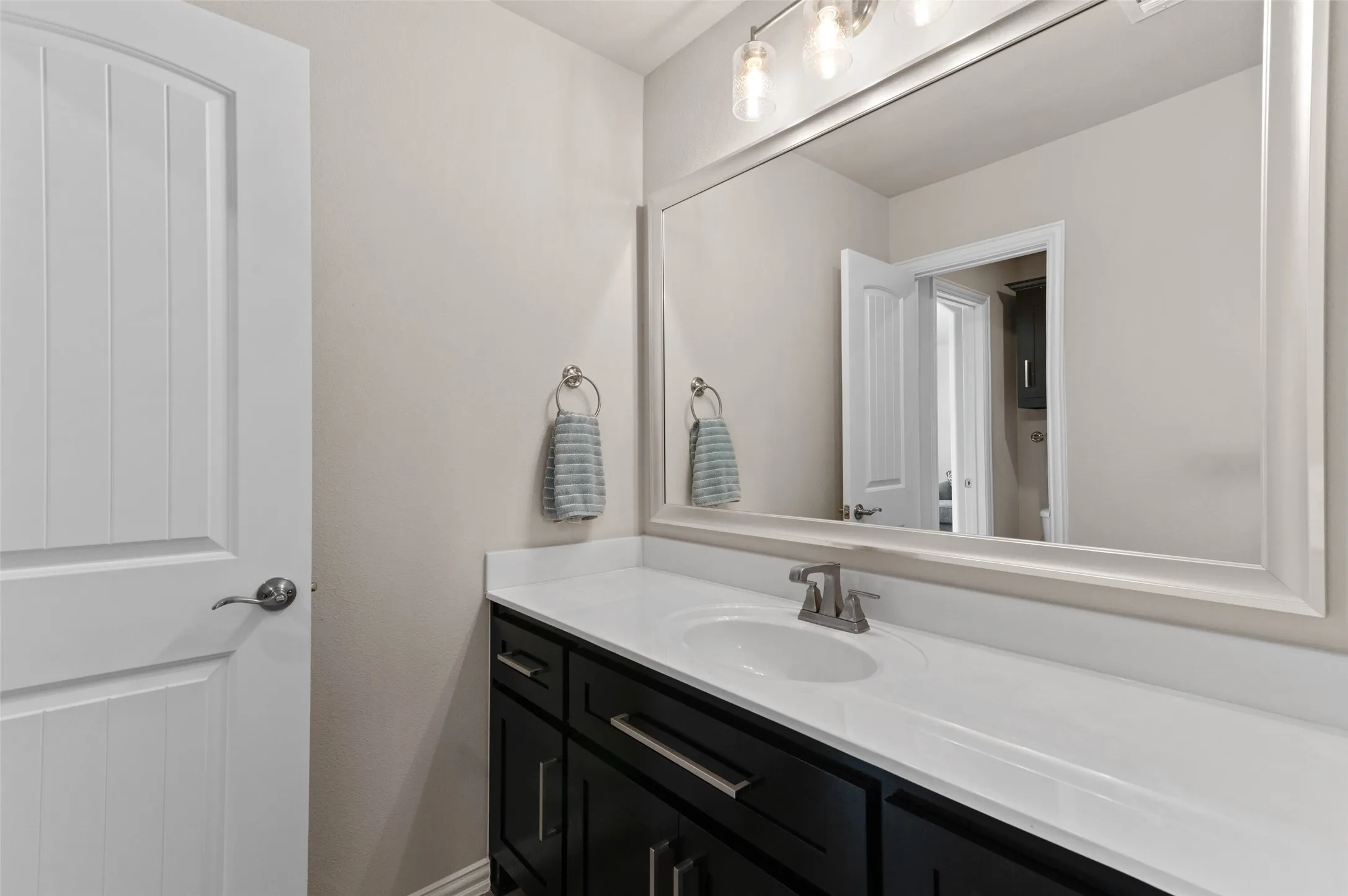 Bathroom vanity featuring a white countertop, undermount sink, and brushed nickel faucet