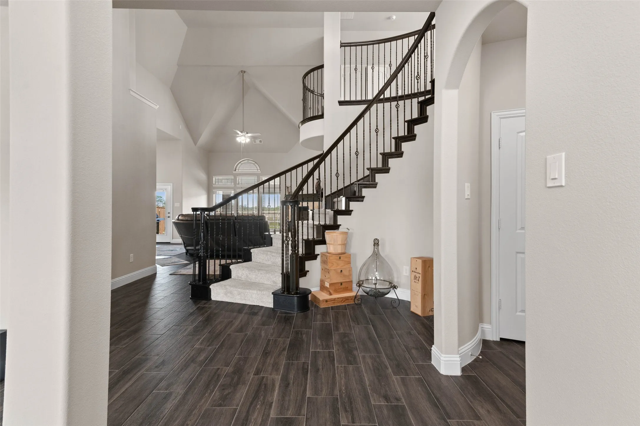 Grand entry featuring a curved staircase with wrought iron balusters and carpeted treads