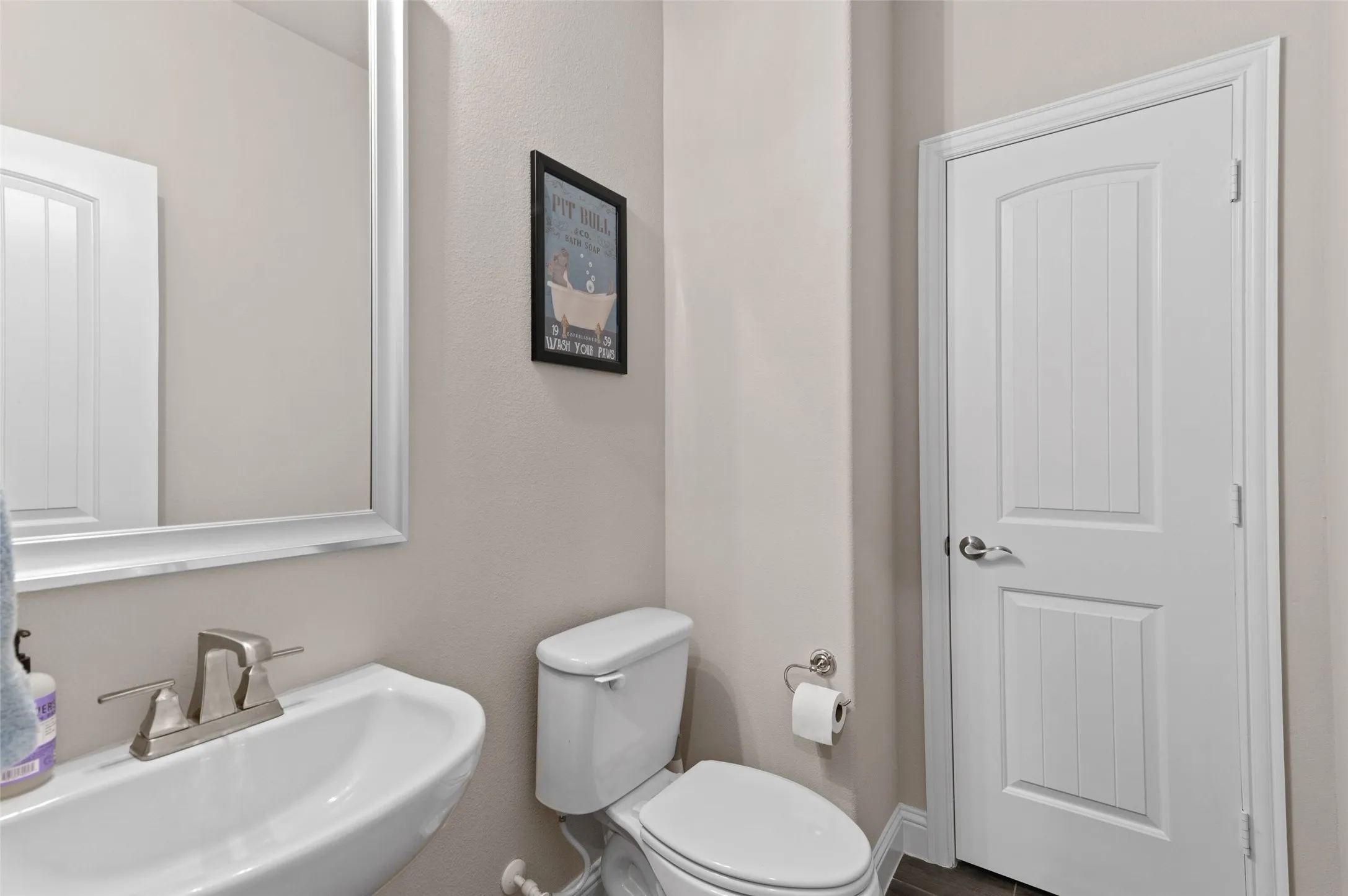 Contemporary powder room featuring a pedestal sink, brushed nickel faucet, and a large wall-mounted mirror