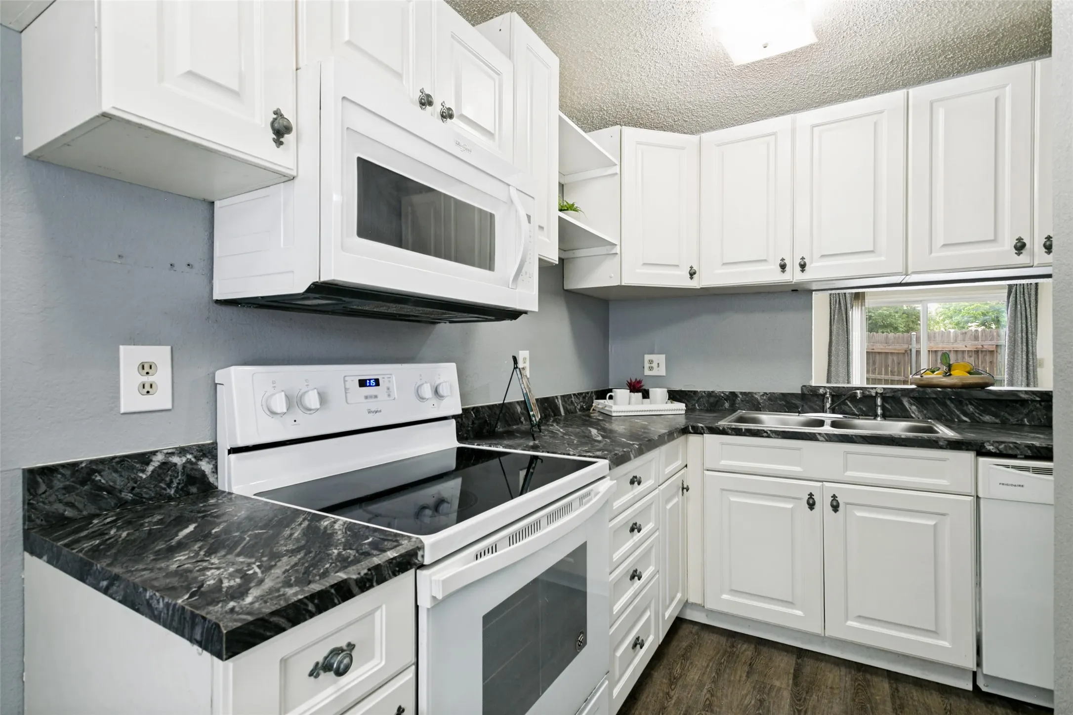 Kitchen with white appliances and cabinets