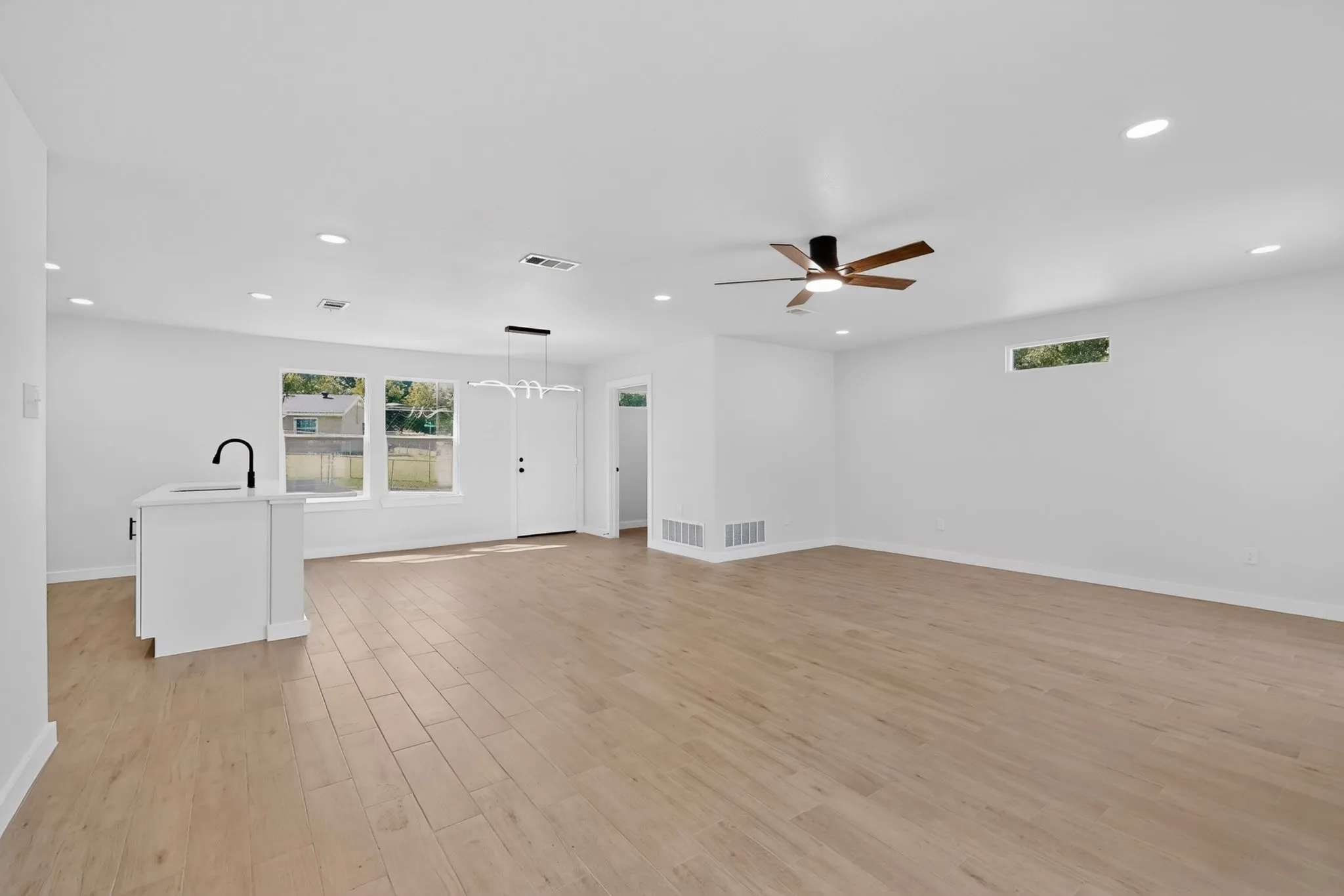Open-concept interior featuring wood-finish flooring, recessed lighting, and a modern ceiling fan