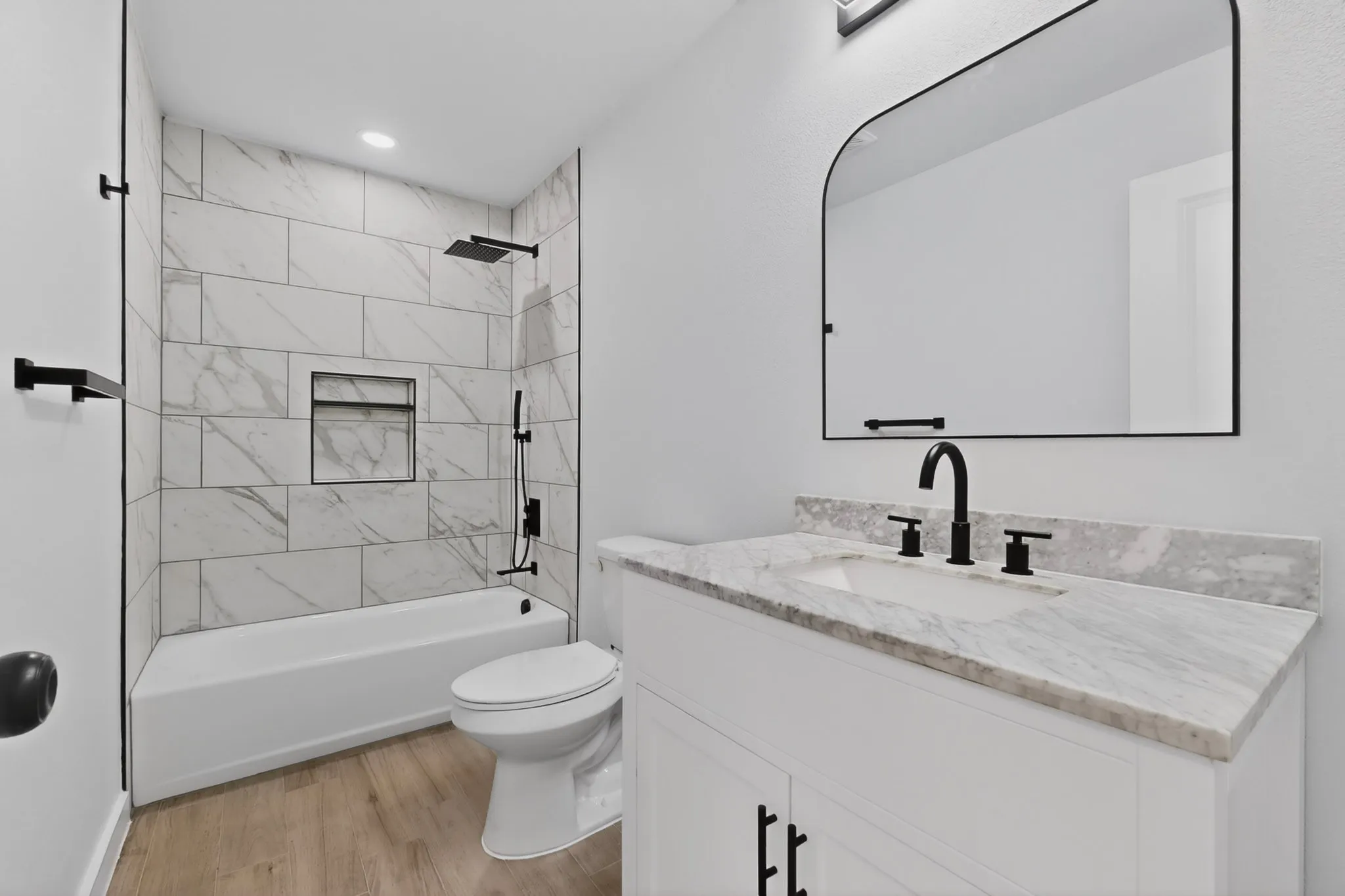 Bathroom featuring a white vanity with a stone countertop, an undermount sink, and matte black fixtures