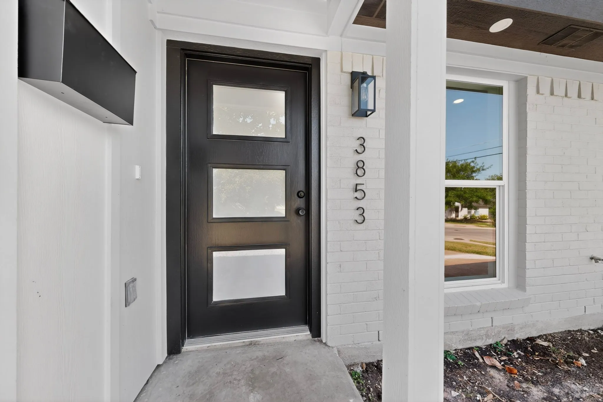 Black modern entry door with three frosted glass panels