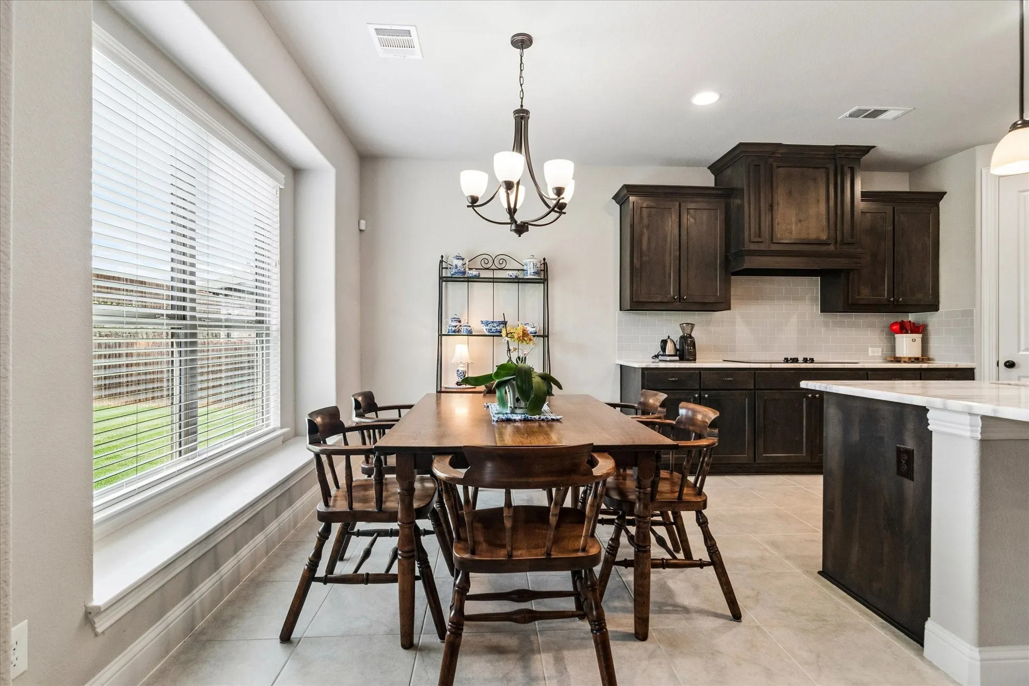 Breakfast area with tile flooring and a large window with a sitting area