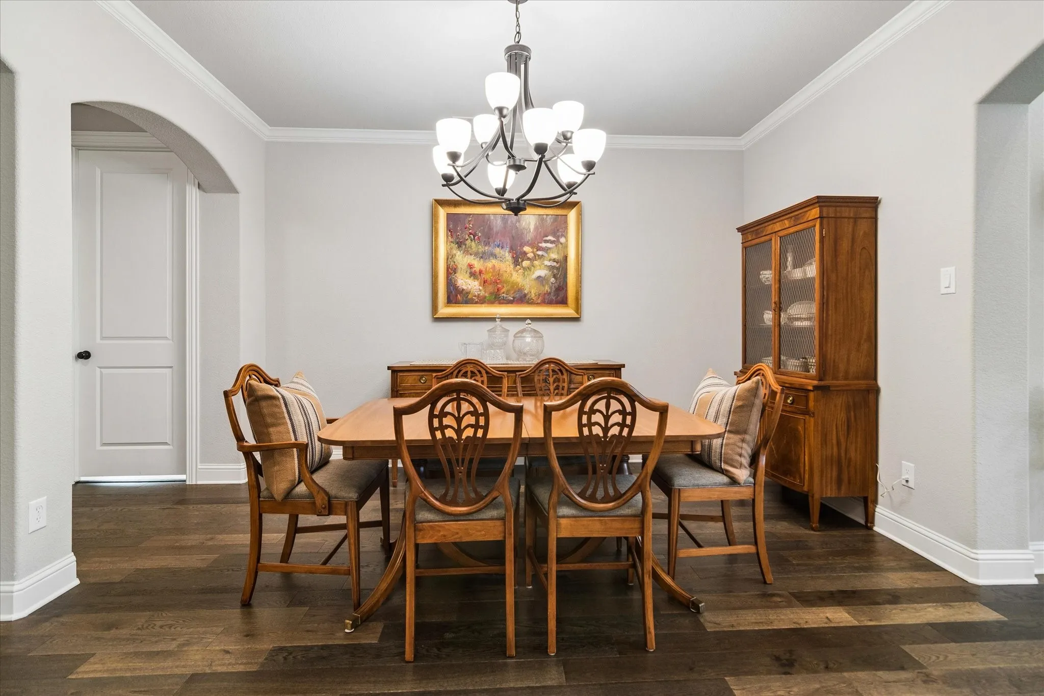 Formal dining area featuring dark wood-finish flooring and decorative lighting