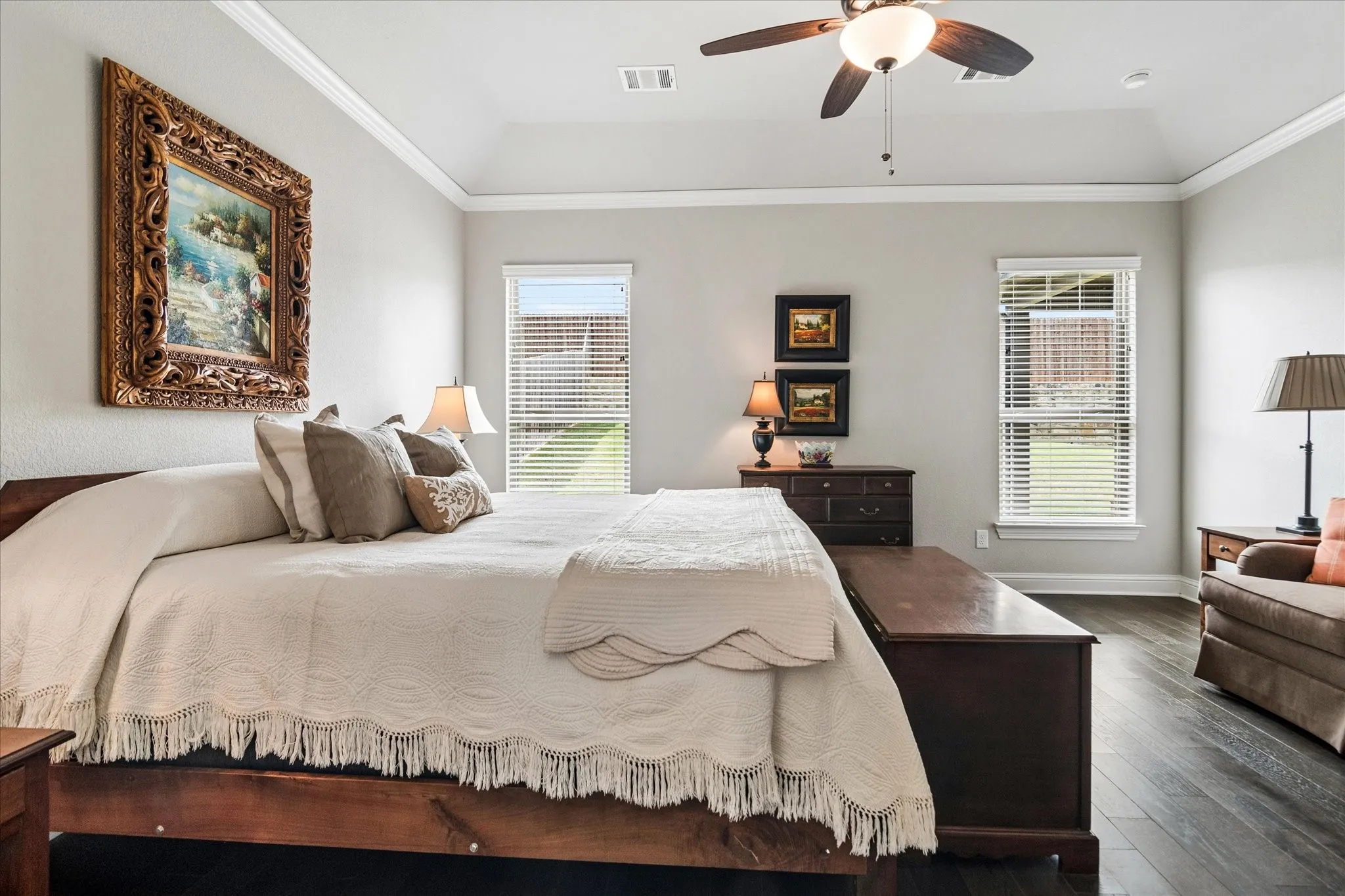 Spacious primary bedroom featuring wood floor and natural light