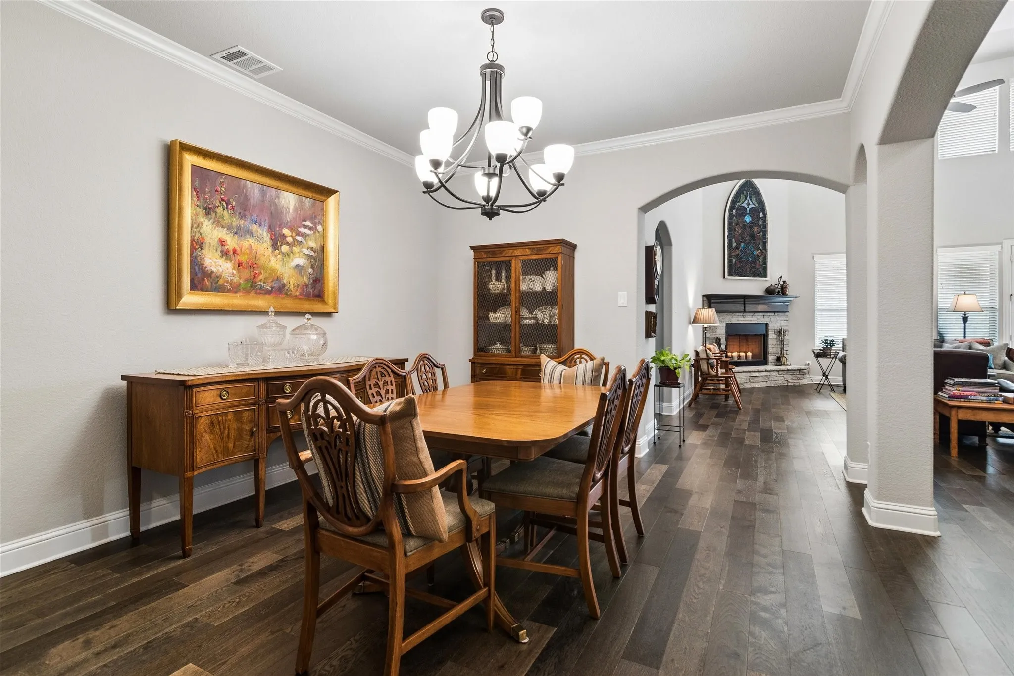 Dining area featuring dark wood-finish flooring and arched doorways