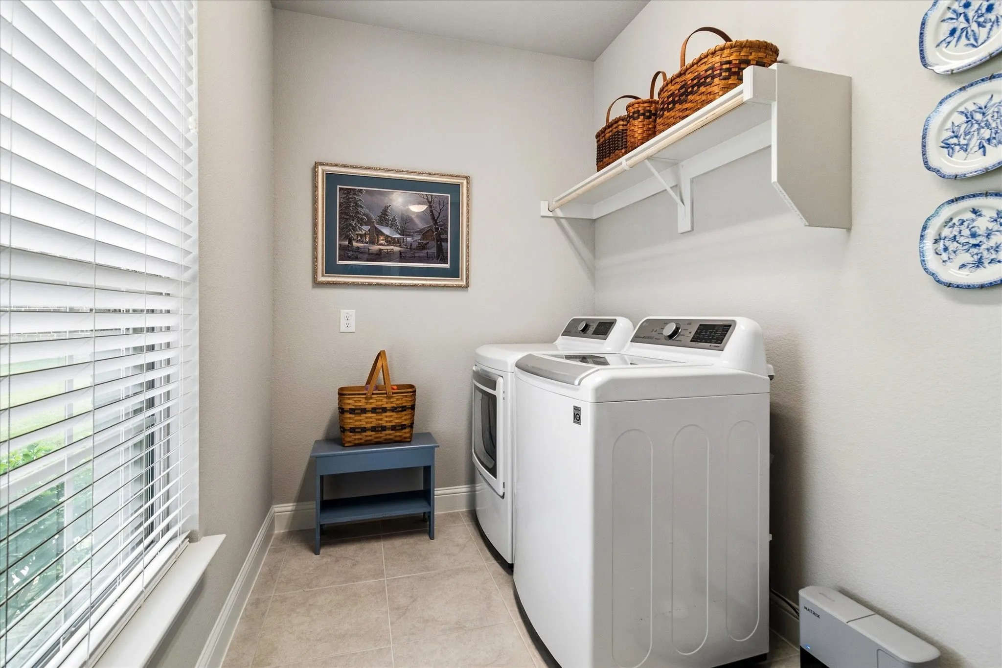 Utility area featuring tile flooring, shelving and drip dry area