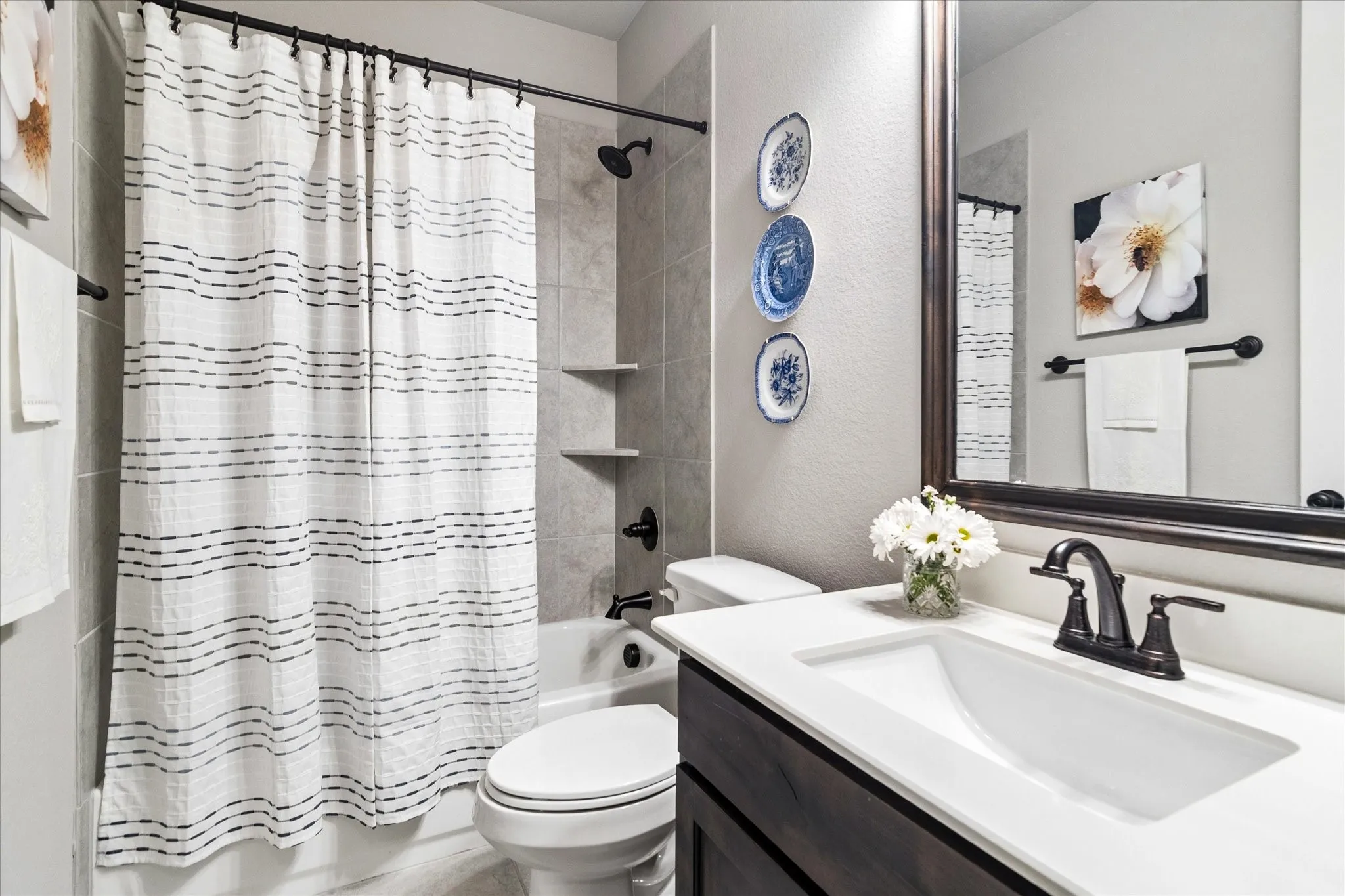 Bathroom featuring a dark wood-finish vanity with a white countertop and an undermount sink