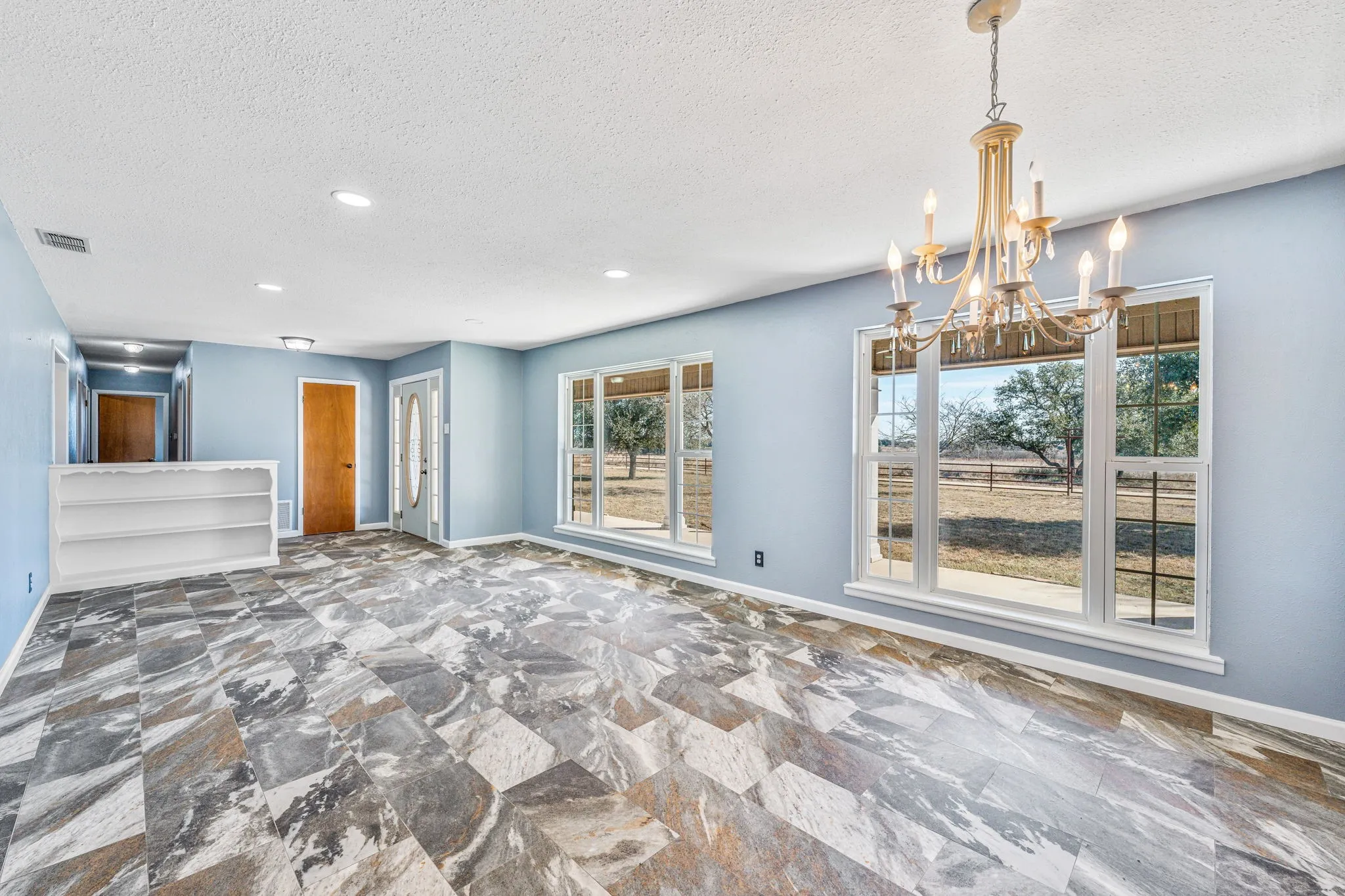 Spacious interior featuring patterned tile flooring and light blue walls