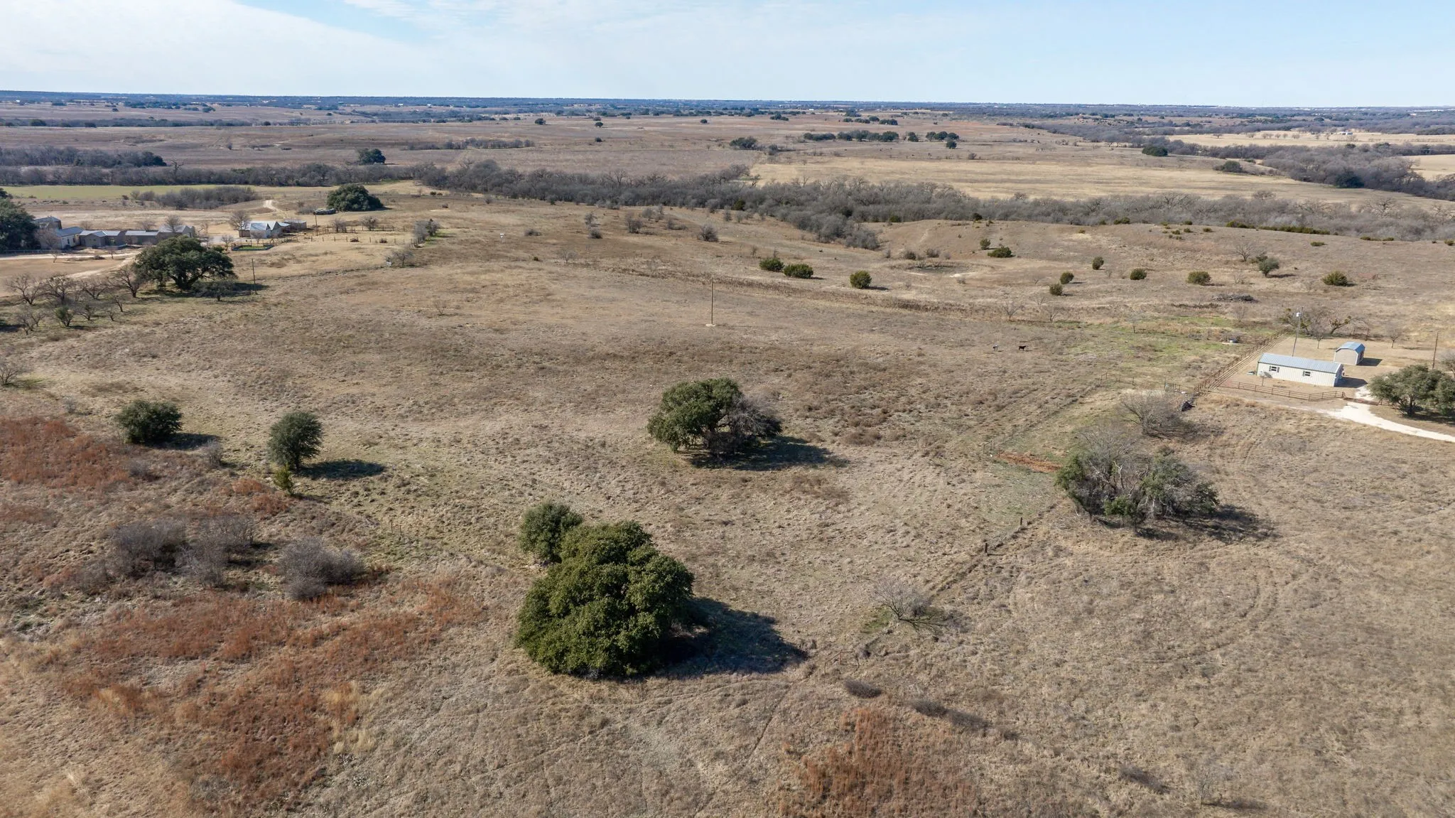 Expansive land parcel featuring natural grasses and scattered mature trees