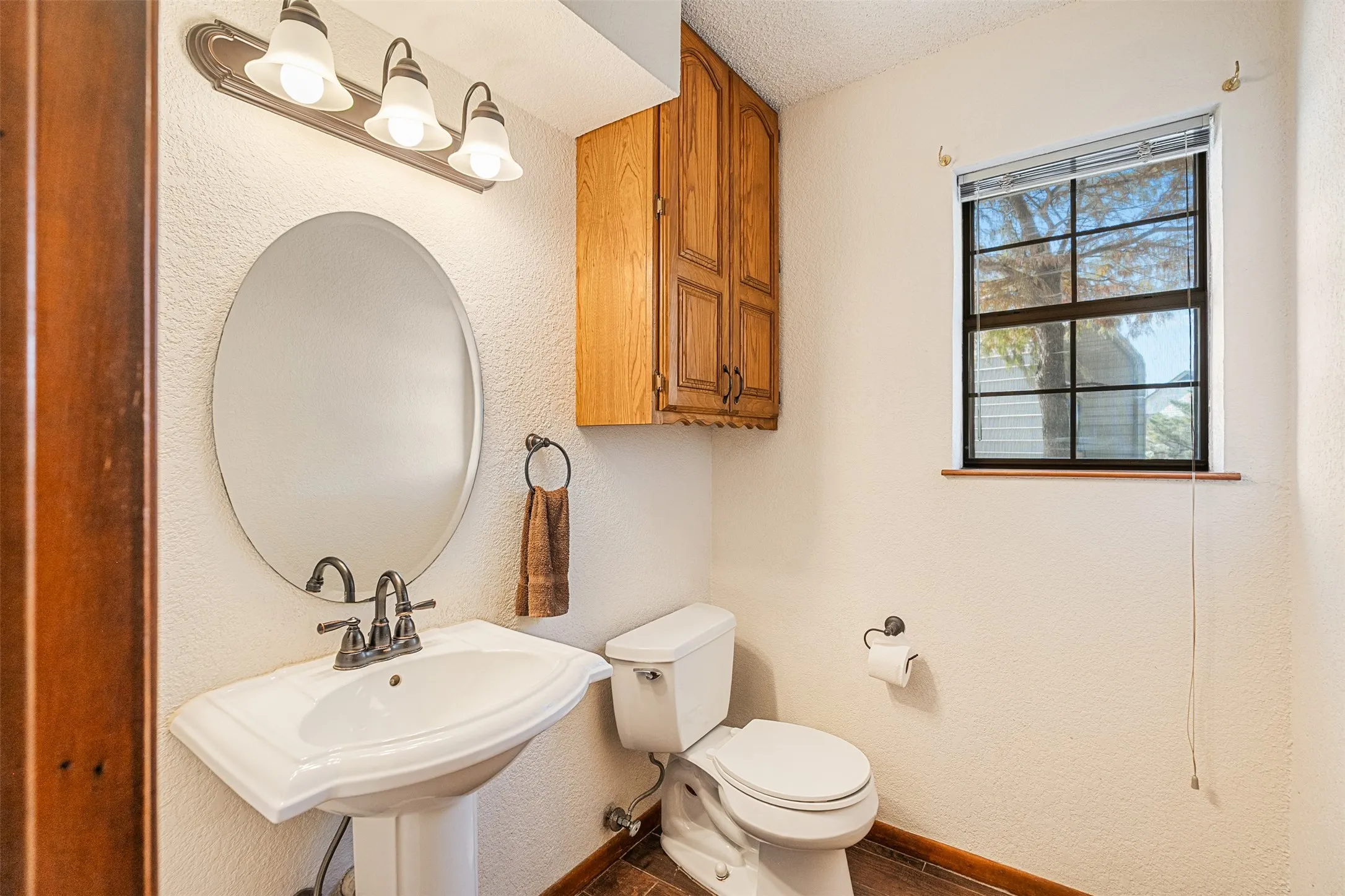 Half bathroom with a textured wall and a textured ceiling