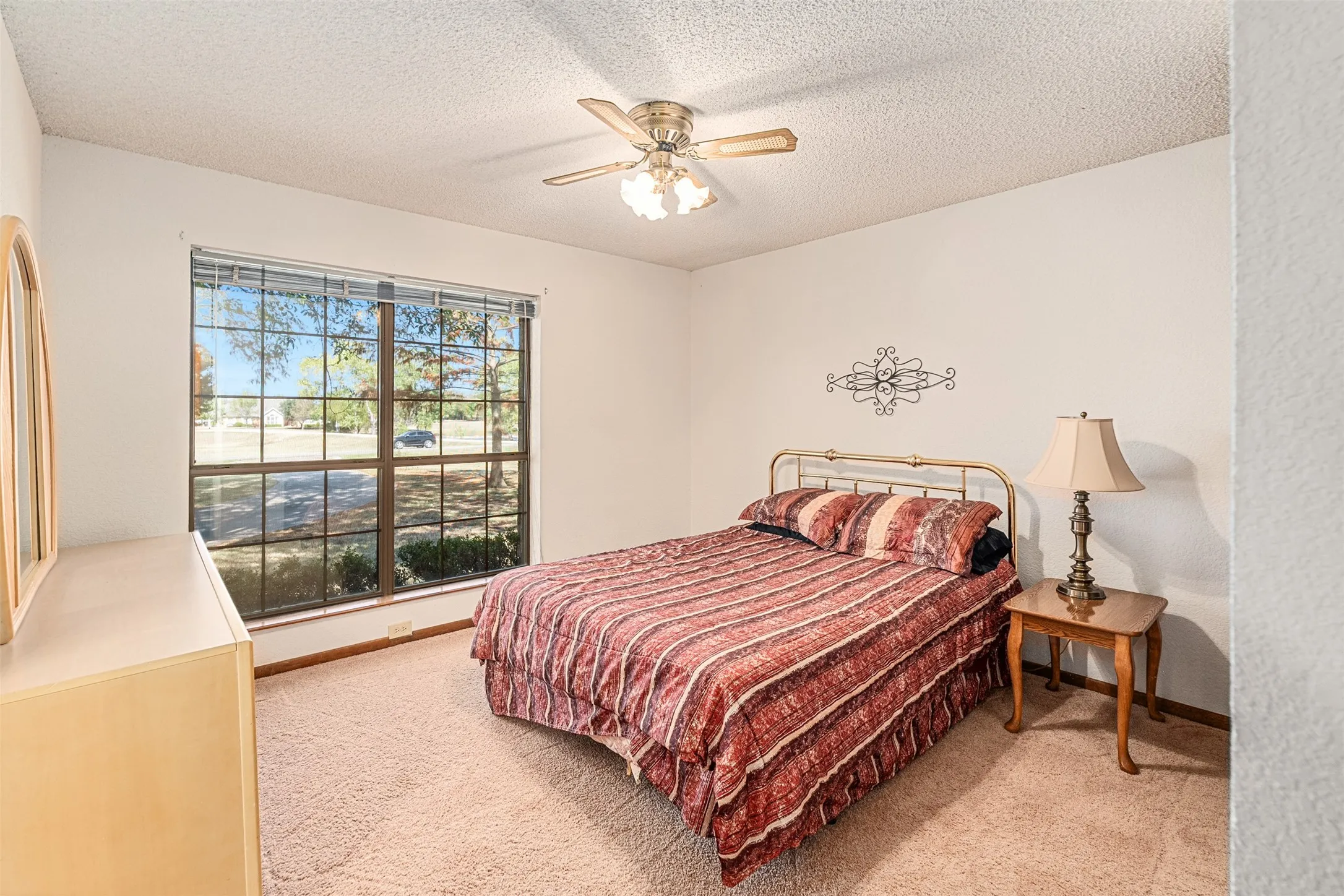 Bedroom featuring light colored carpet, ceiling fan, and a textured ceiling