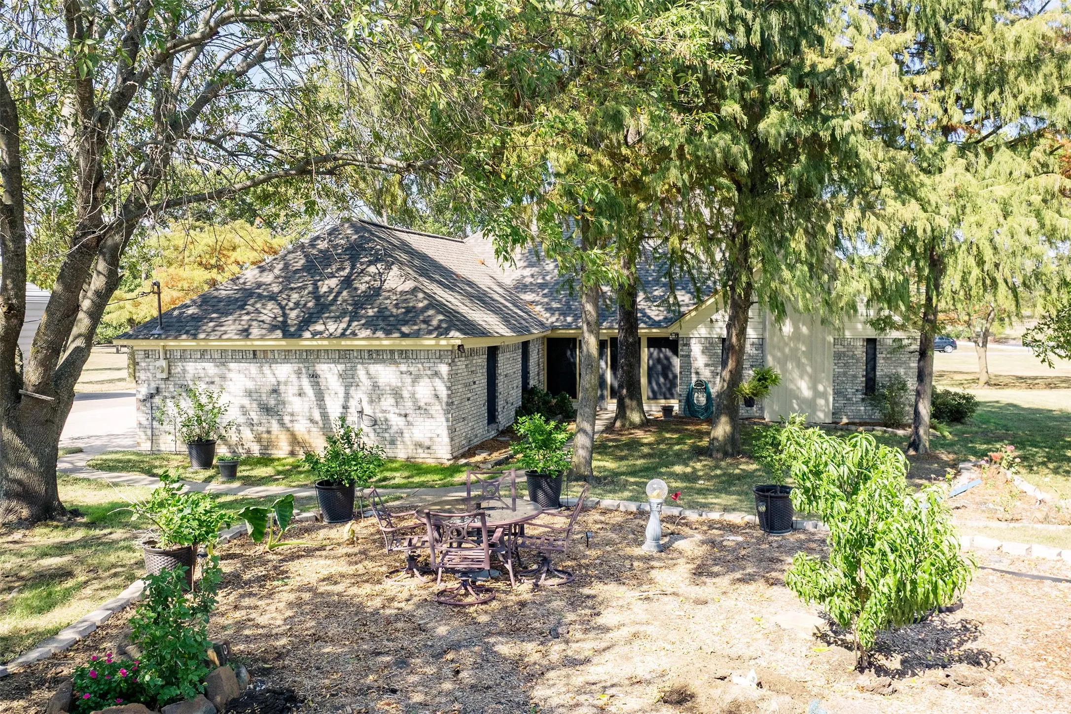 View of back of property with brick siding and roof with shingles
