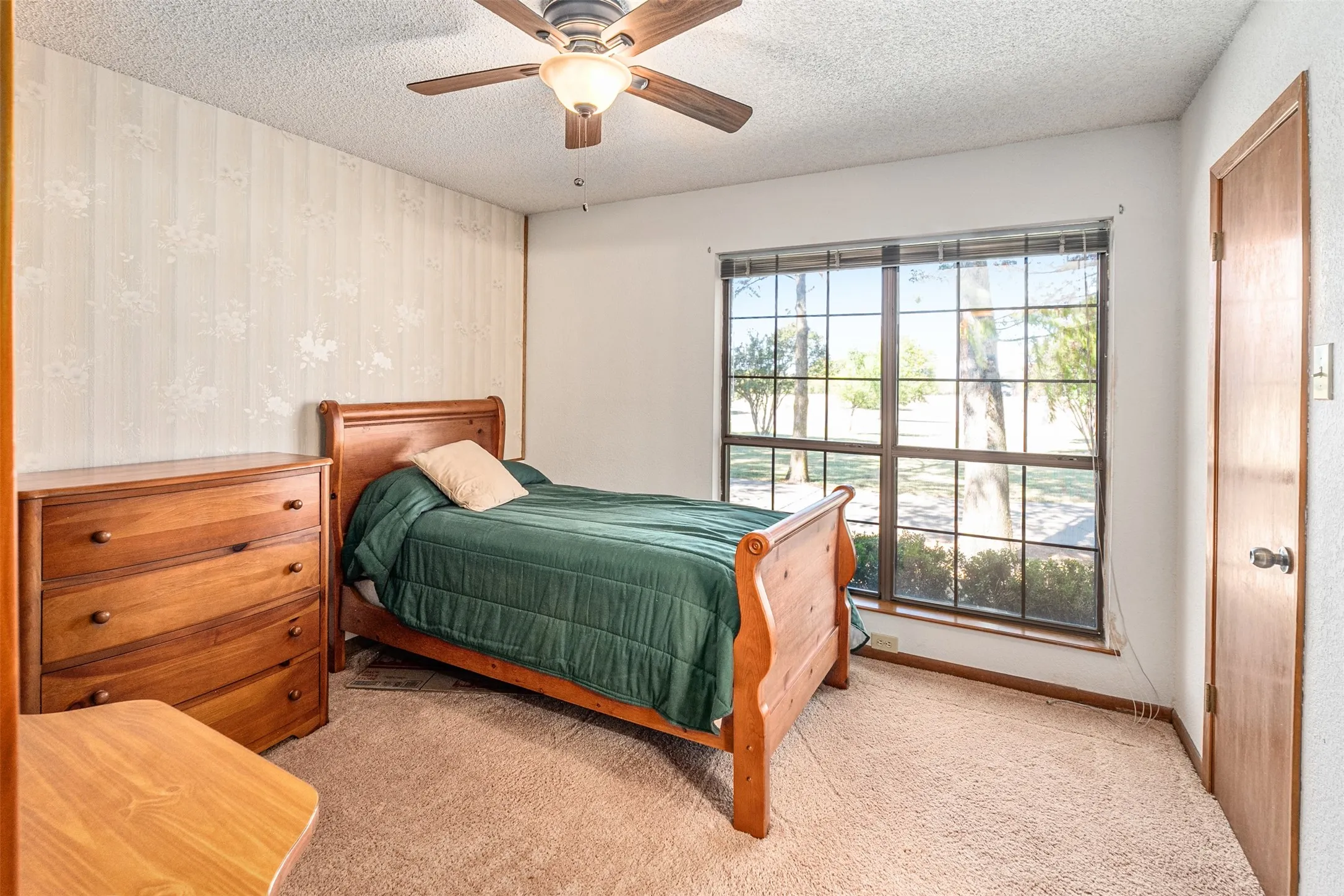 Bedroom featuring carpet flooring, a ceiling fan, and a textured ceiling
