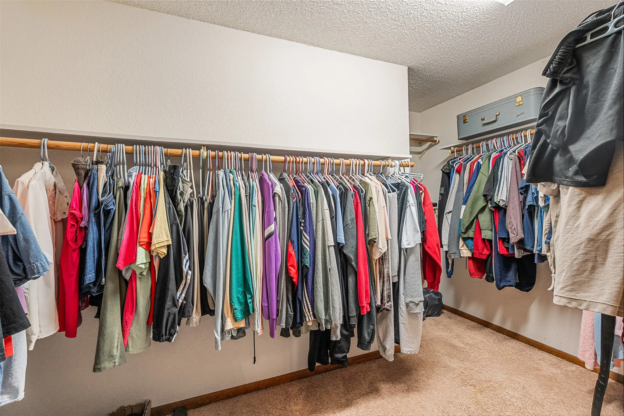 Spacious master bedroom closet with carpet