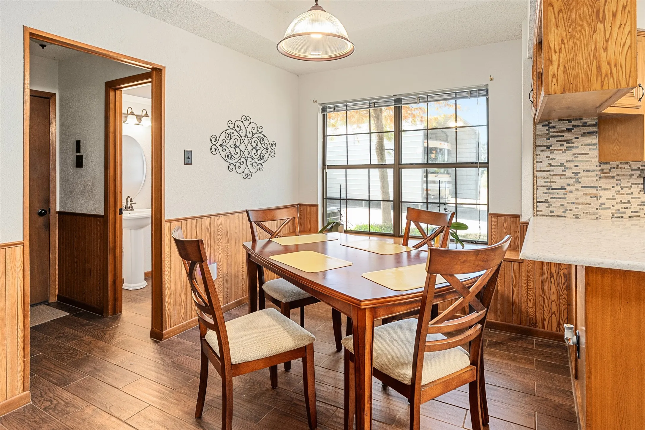 Dining area featuring dark wood-type flooring, wainscoting, and wood walls