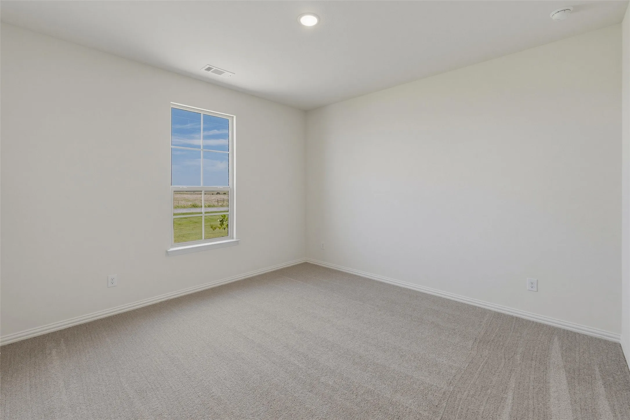 Spacious room with a single window providing natural light