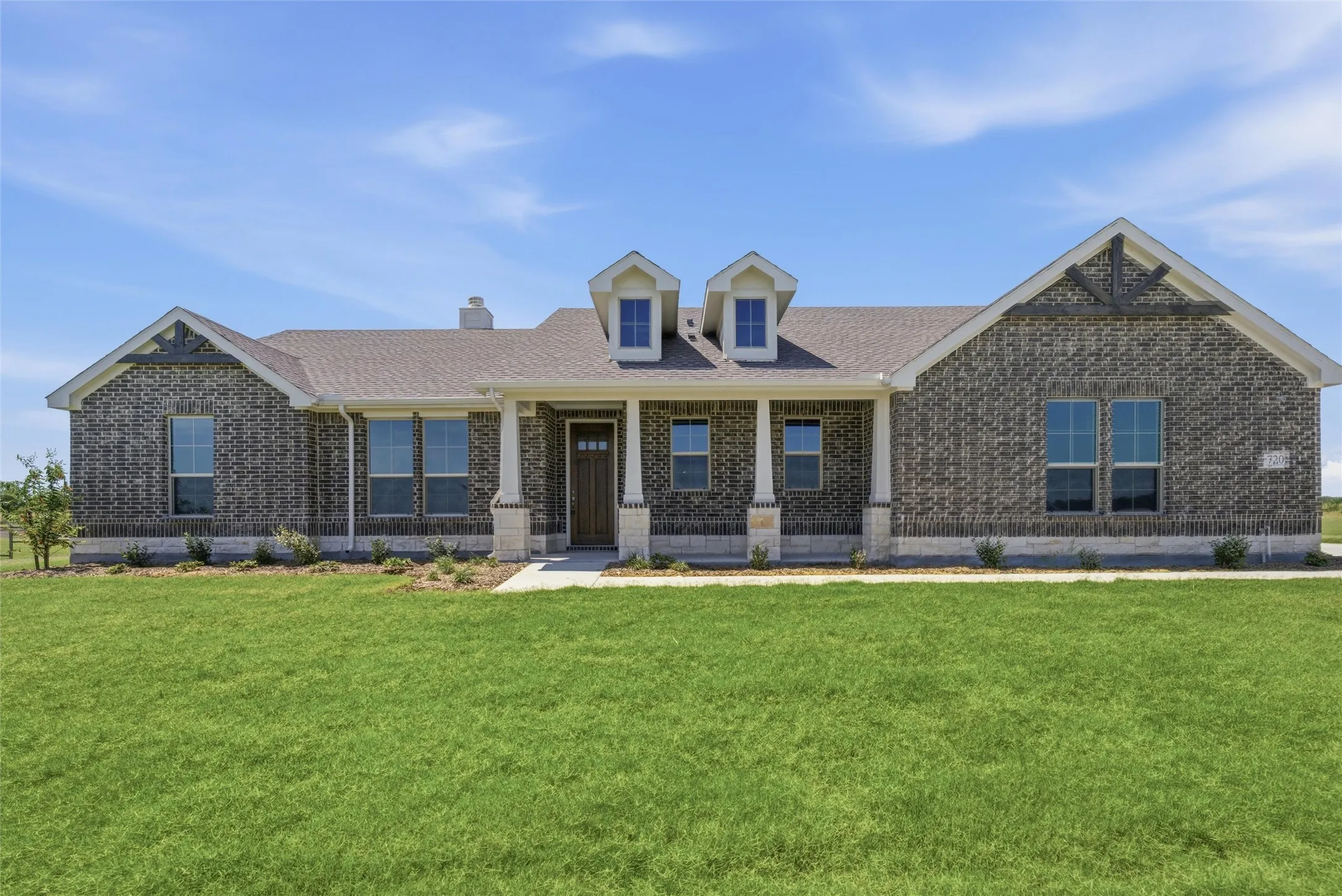 Ranch-style residence featuring a dark brick exterior and a gabled roofline