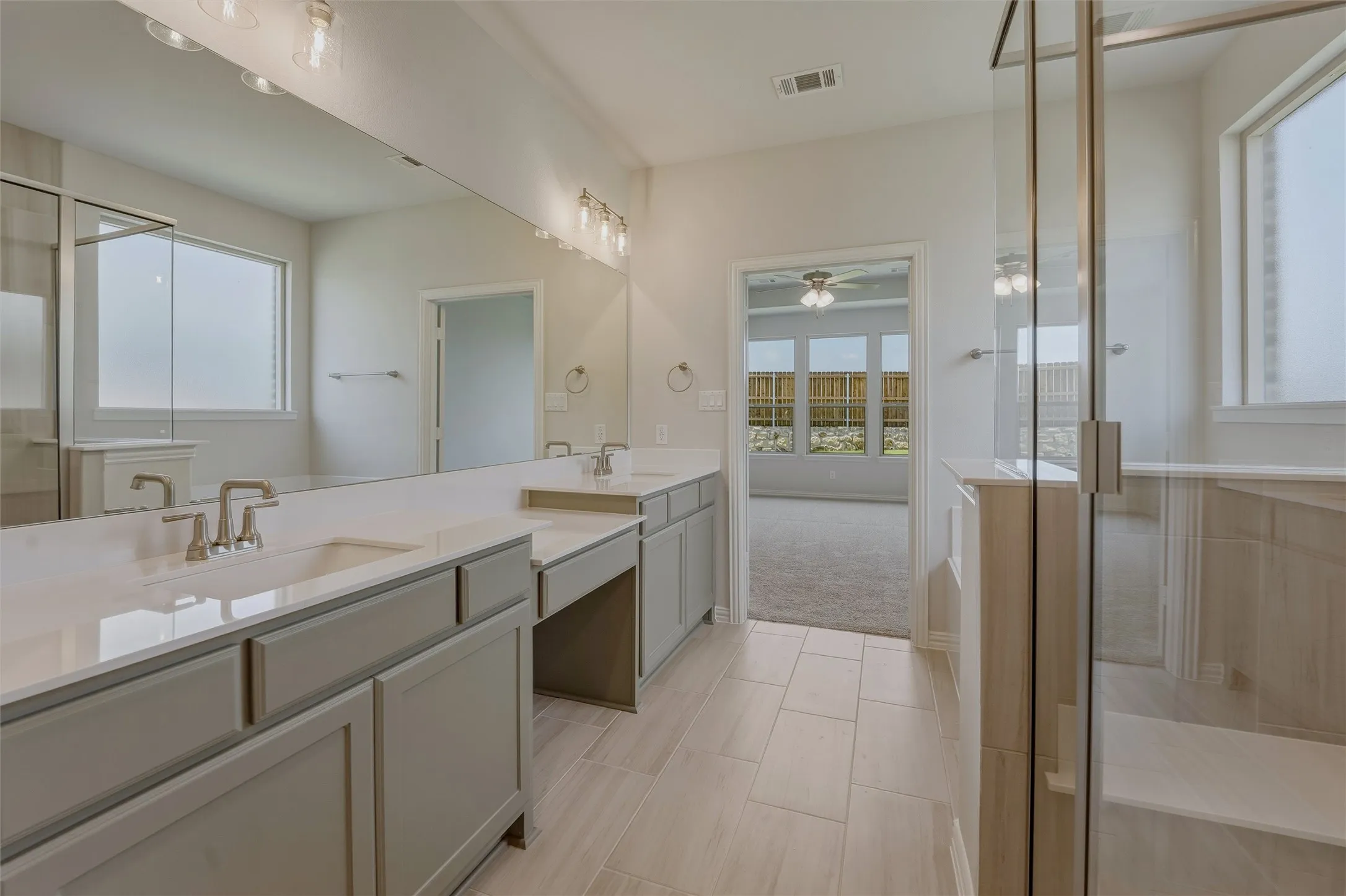 Double vanity featuring light grey cabinetry, integrated sinks, and brushed nickel faucets