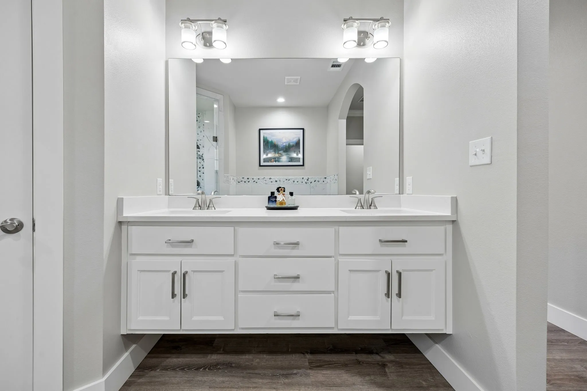 Double vanity with white cabinetry, integrated sinks, and quartz countertops