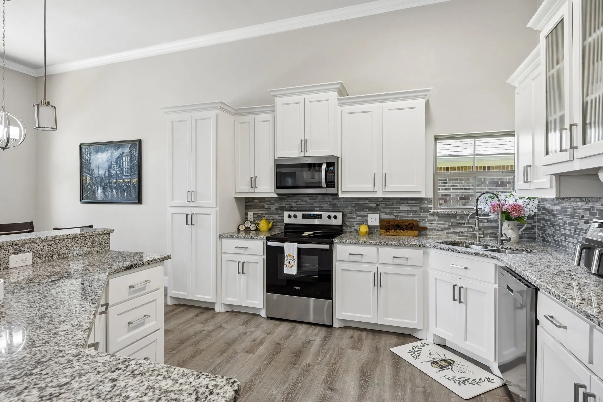 White cabinetry and granite countertops with a mosaic tile backsplash