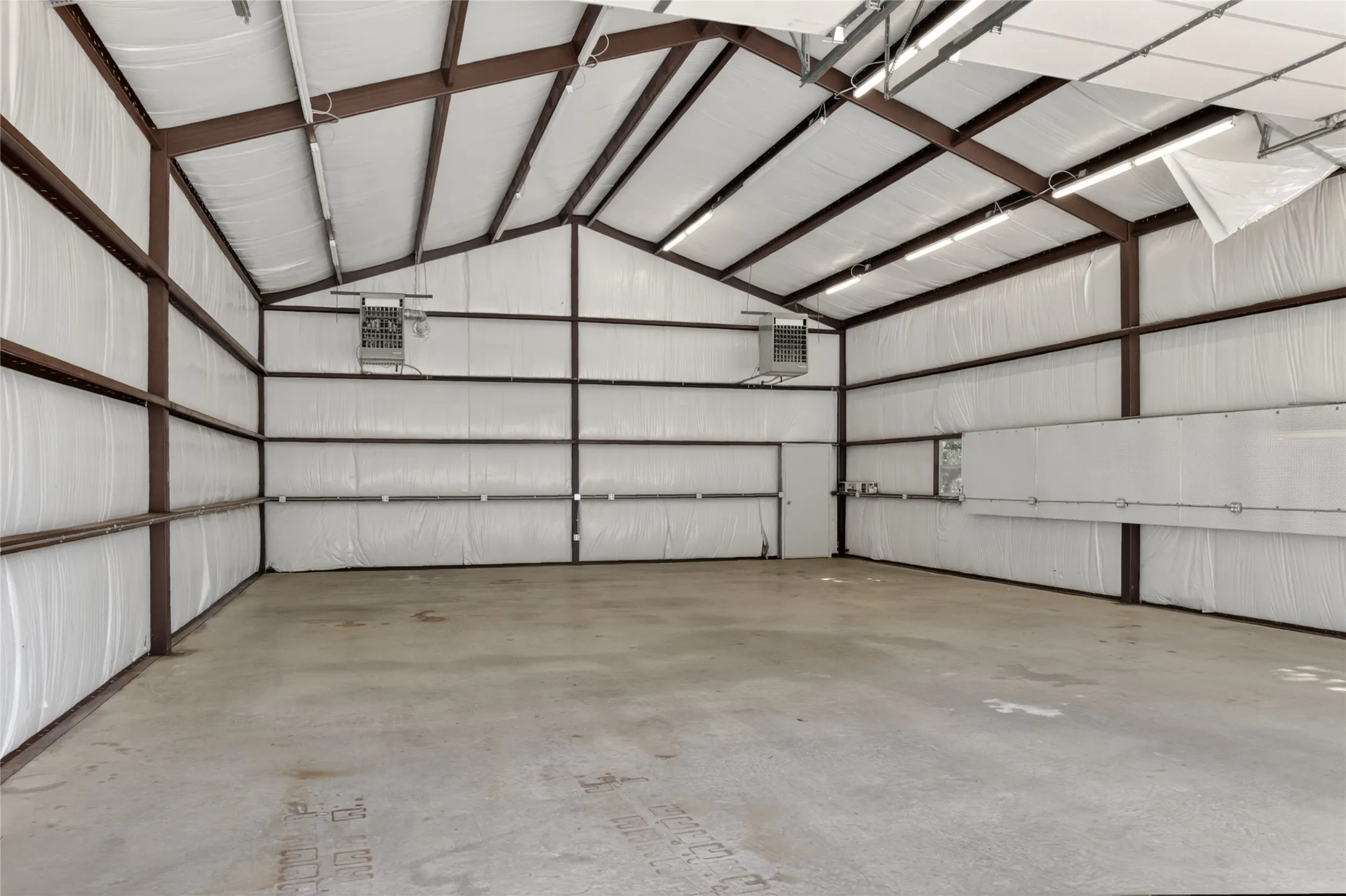 Inside view of the 30x50 heated workshop. On the outside of the workshop there's a parking pad right next to it for additional RV parking