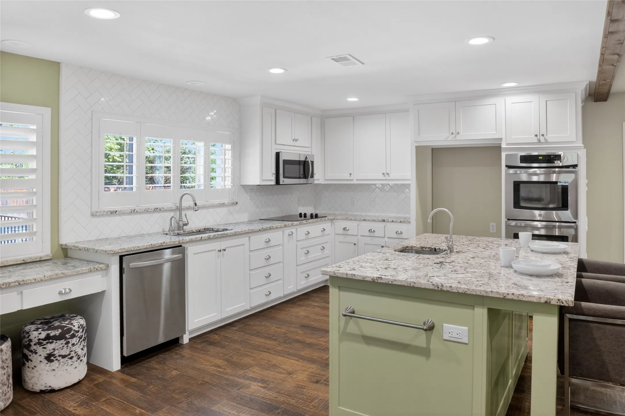 Updated kitchen features a double oven, farm sink, utility desk and a large island with a second sink
