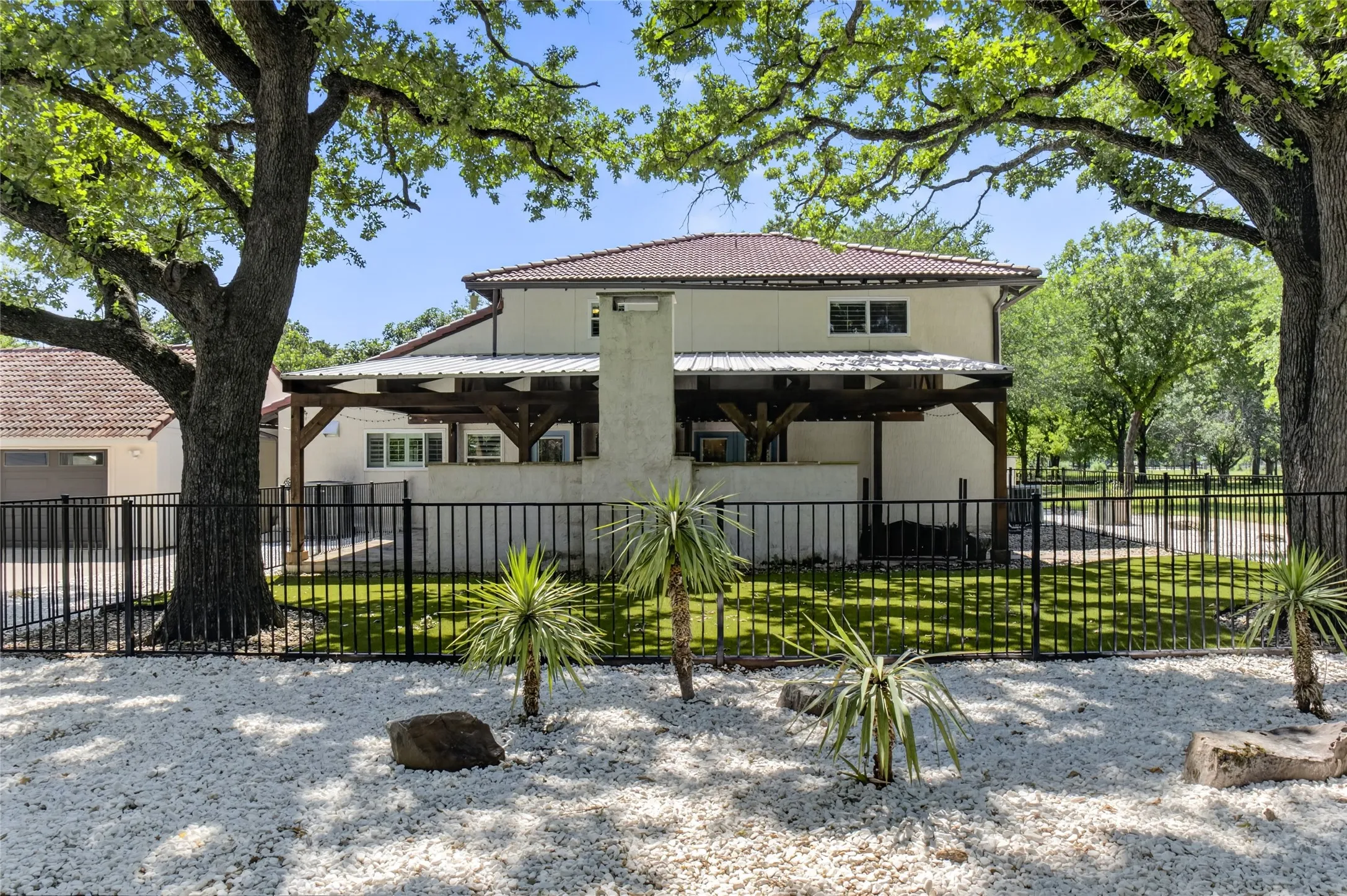 Beautiful setting of gated back courtyard with turf dog run