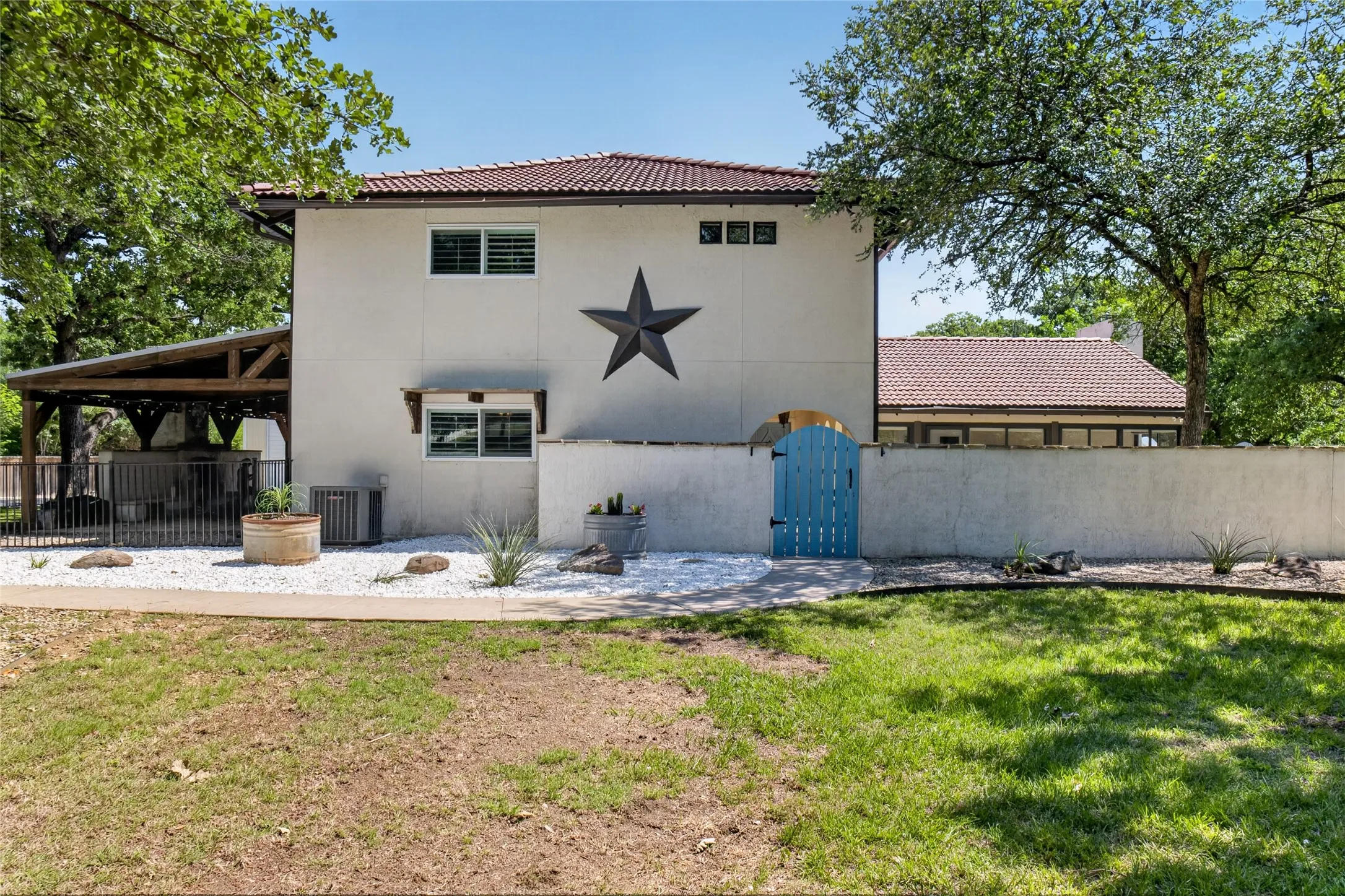 Sidewalk to the entry leads you to a gate that opens into the front courtyard