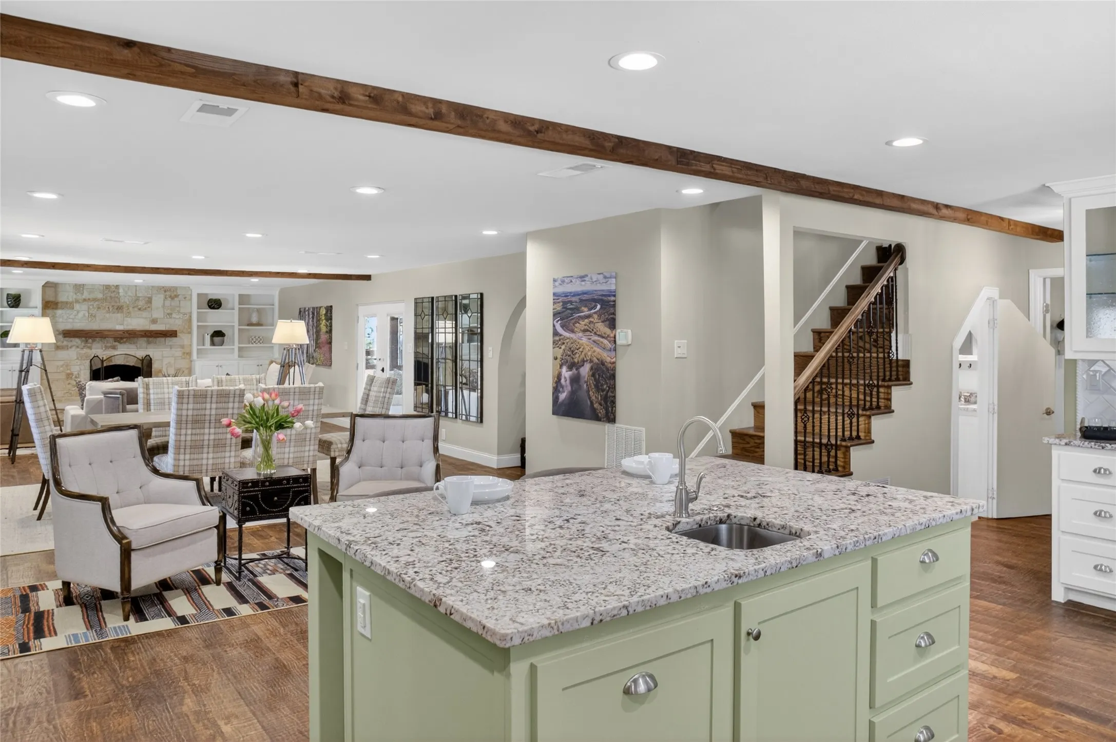View looking into the main living areas from kitchen which features a large island with a second sink