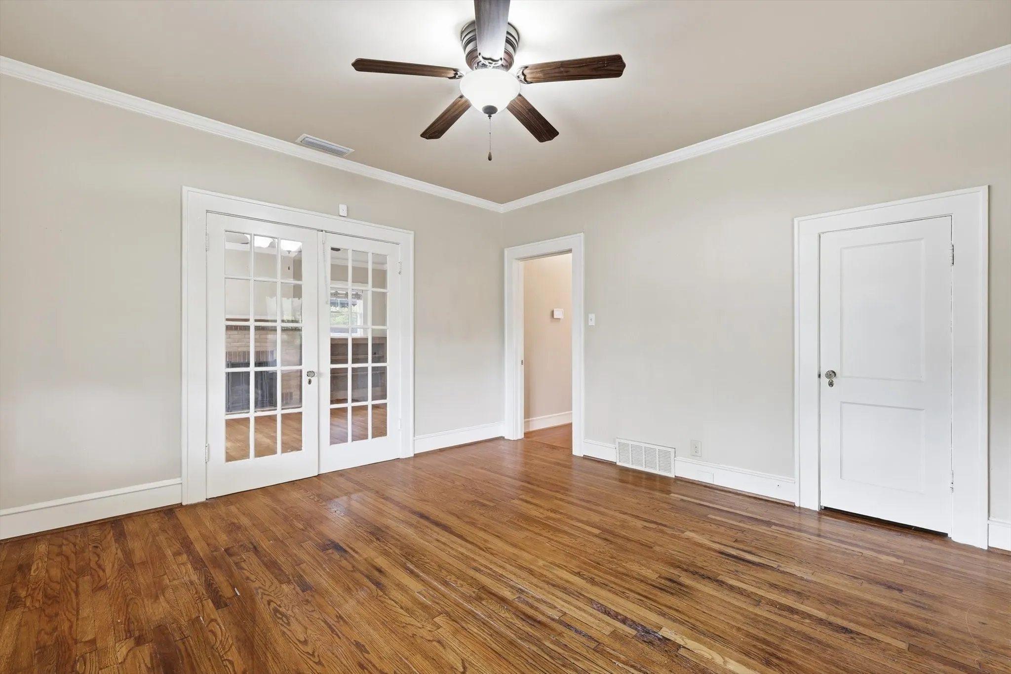 Flexible living area with large windows, hardwood flooring, and abundant natural light.