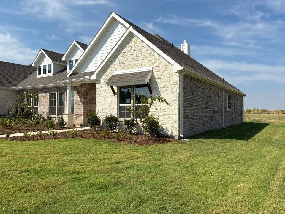 Multi-textured stone and brick exterior with white trim