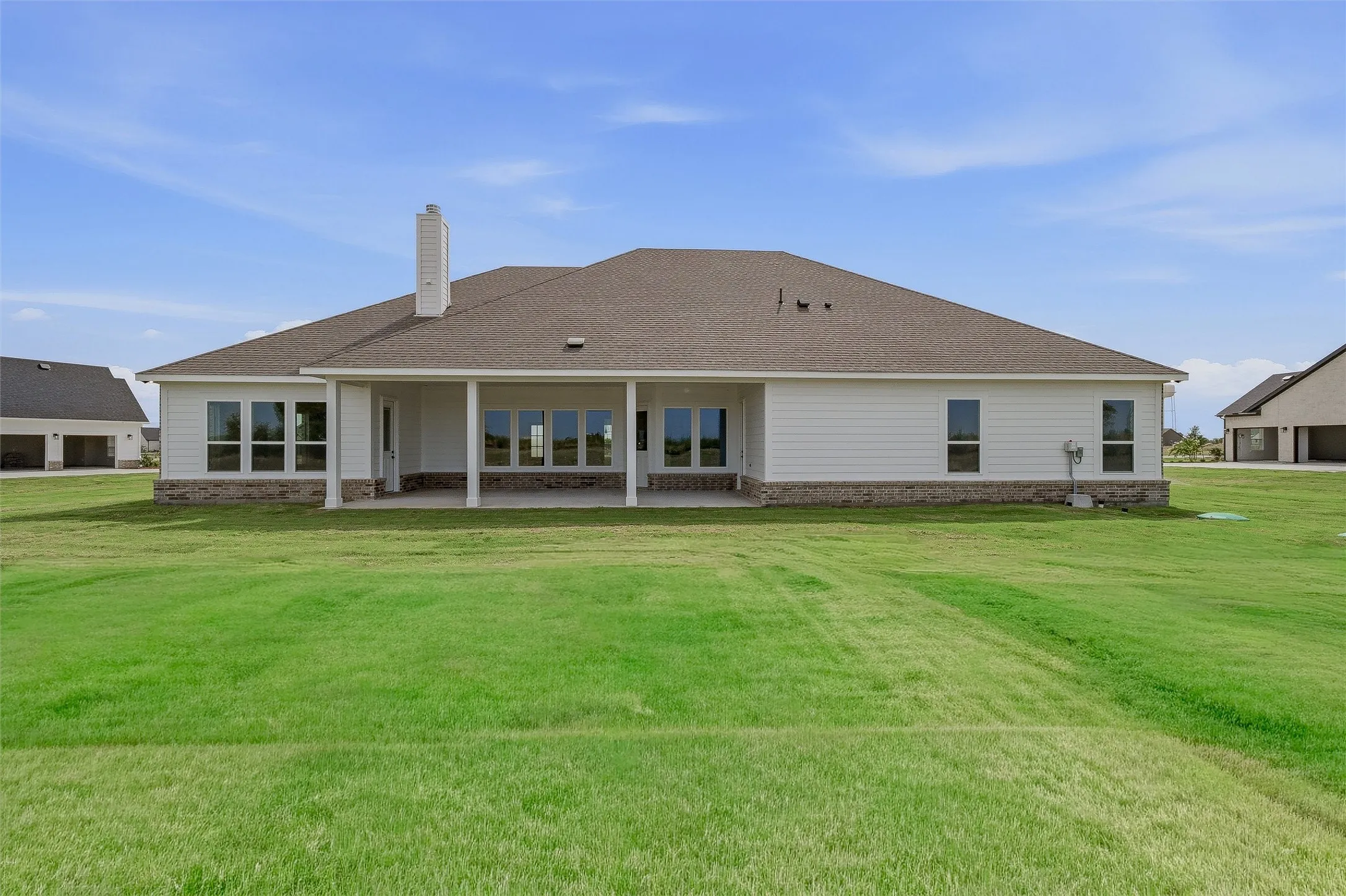 Expansive green lawn surrounds the property