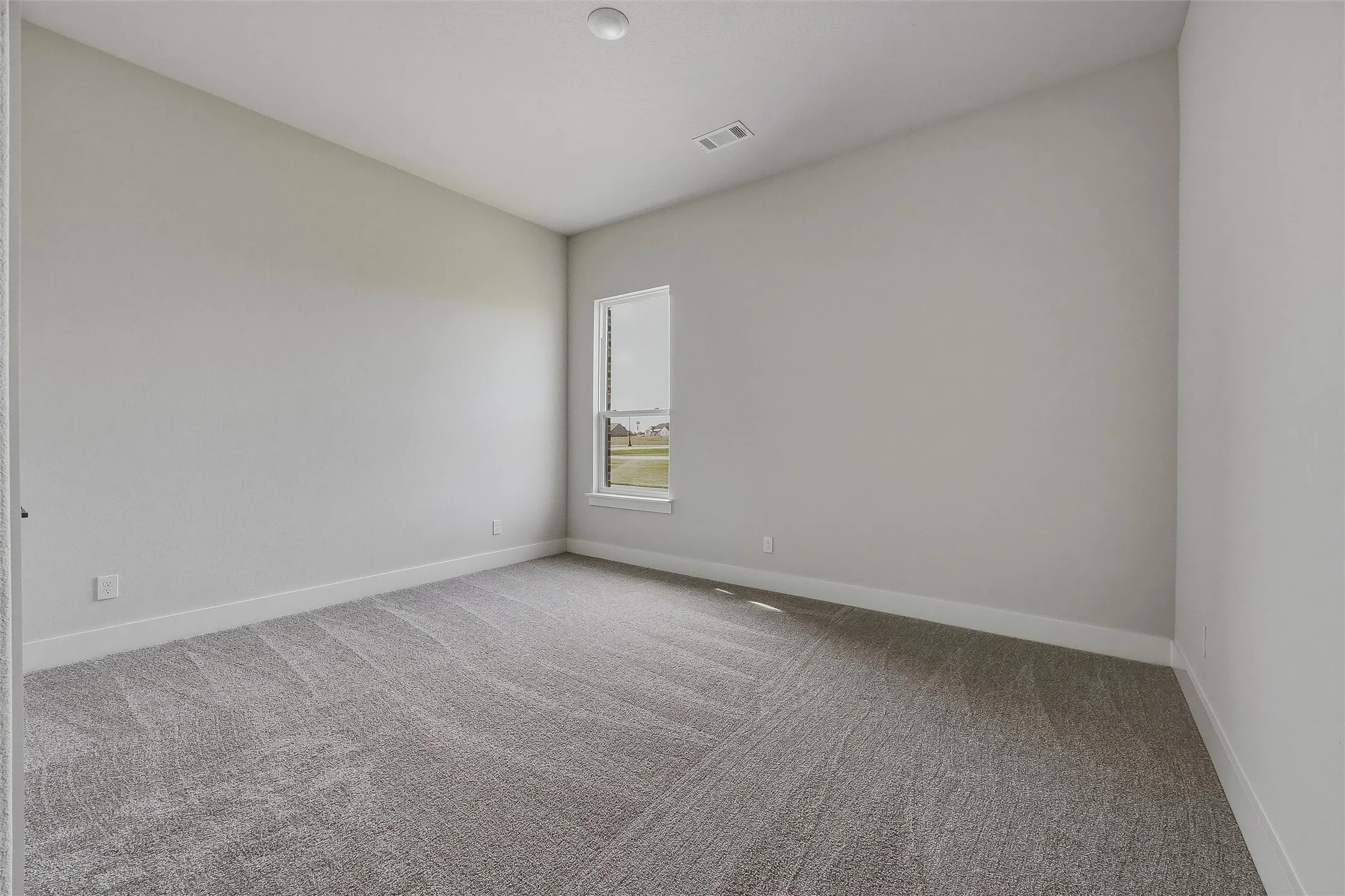 Neutral-toned walls, gray patterned carpet, and a white-trimmed window