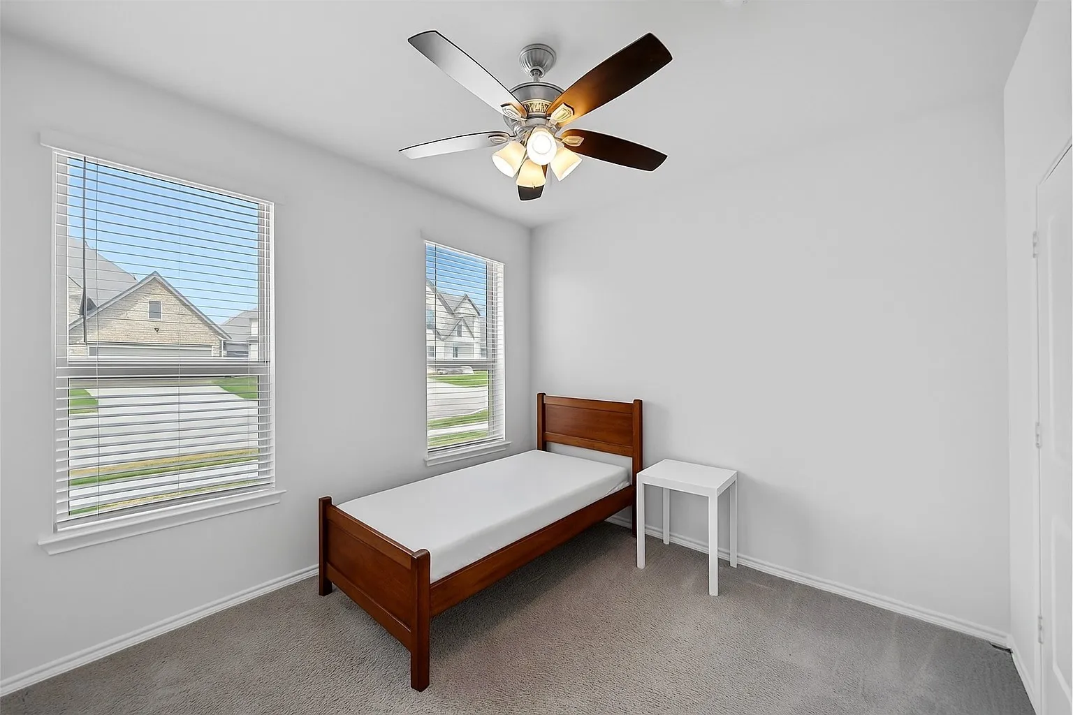Carpeted bedroom with a ceiling fan and baseboards