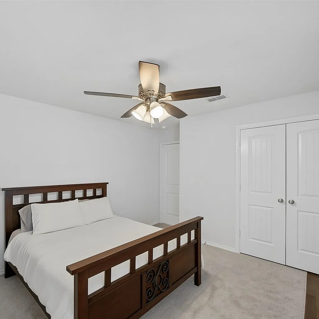 Bedroom featuring light colored carpet, ceiling fan, and a closet
