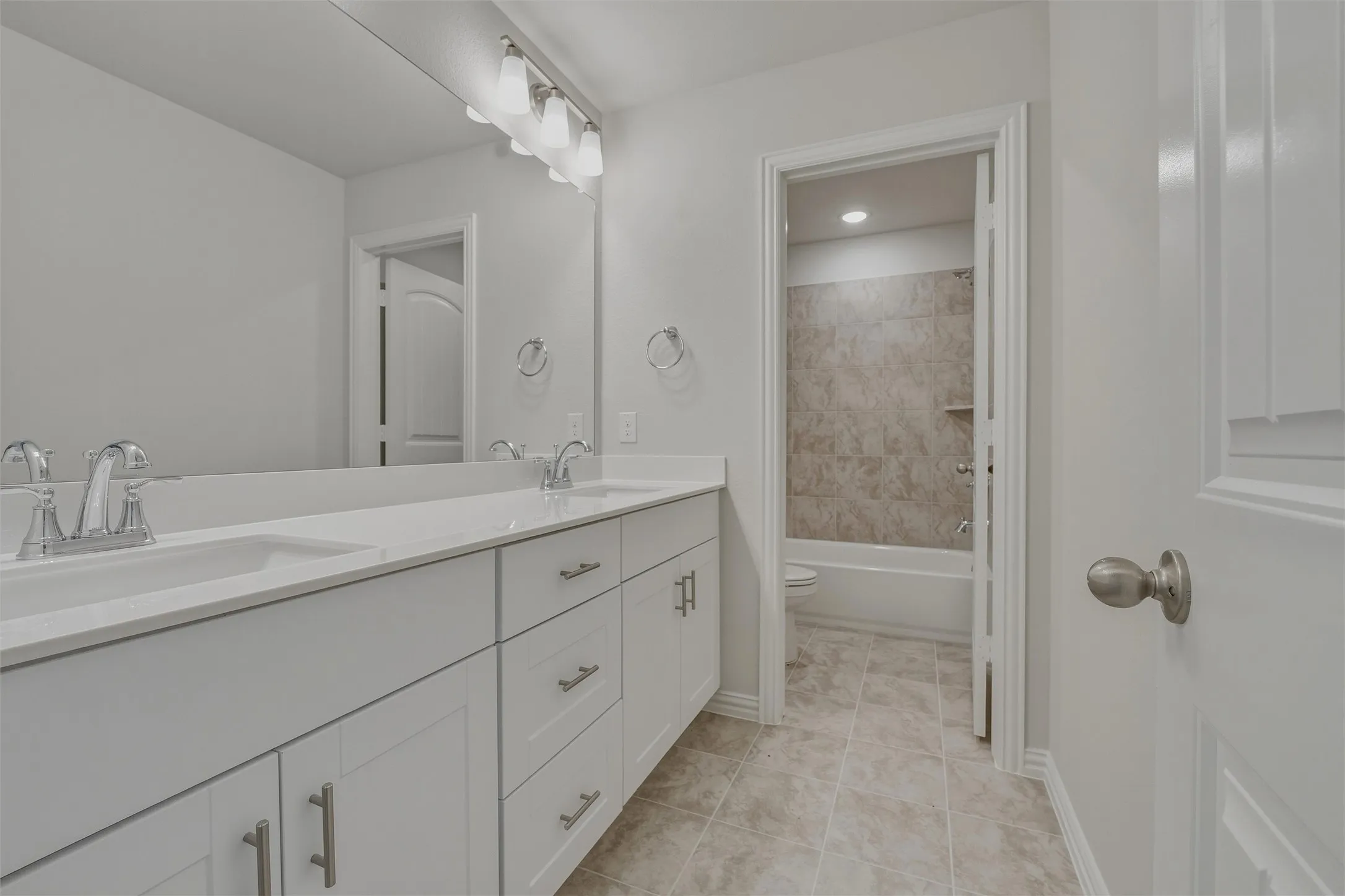 Dual vanity with undermount sinks and chrome faucets set against a full-width mirror