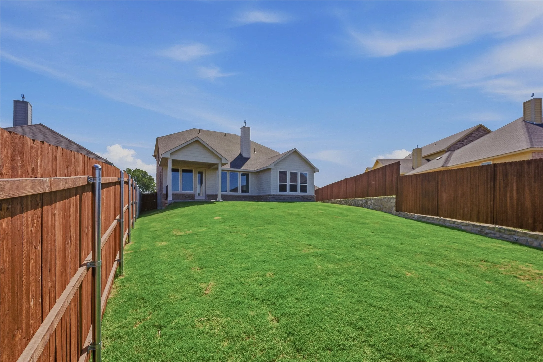 Expansive green lawn with a wood privacy fence