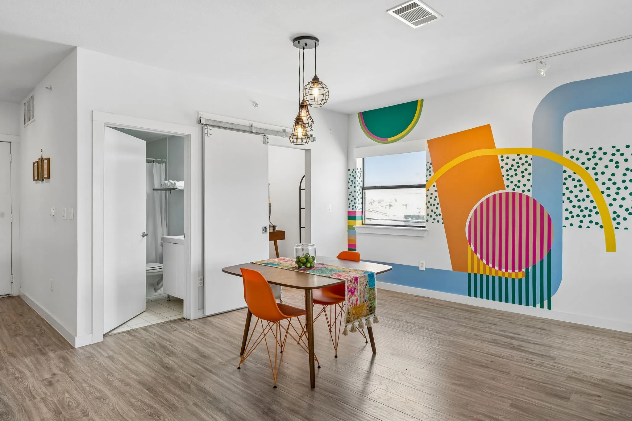 Currently styled as a dining space, this flexible area was originally designed as the secondary bedroom within the open loft-style floor plan.
