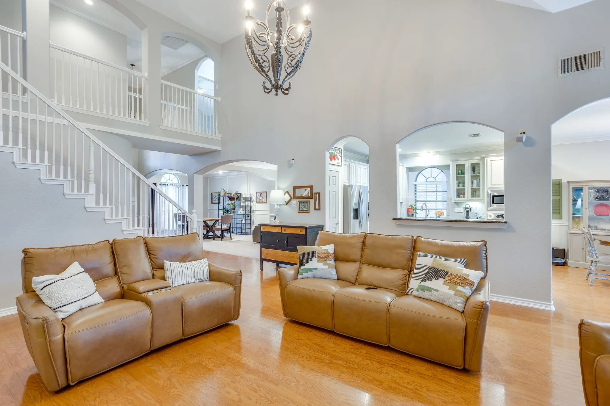 Two-story living area featuring a vaulted ceiling and wood-finish flooring