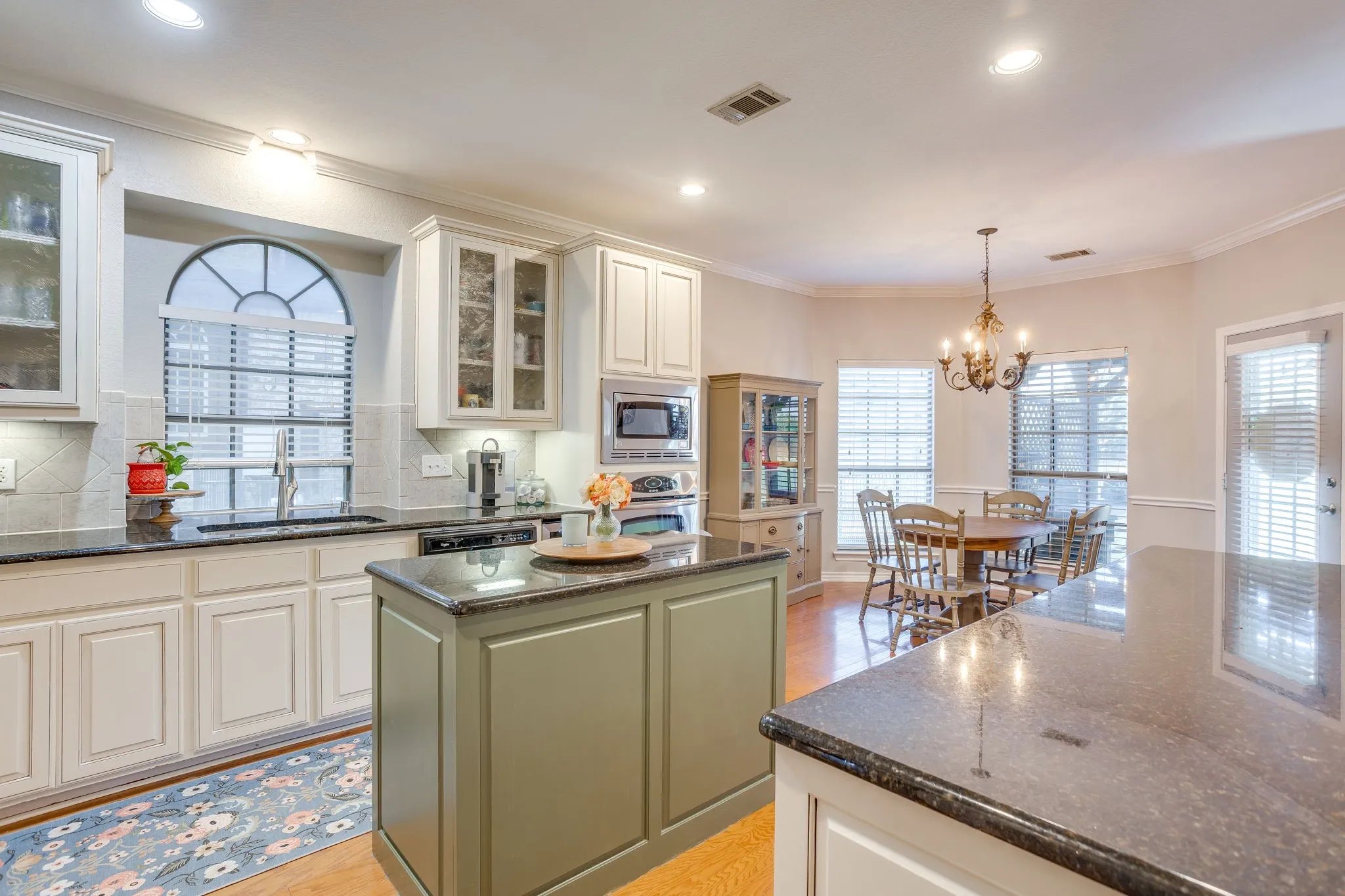 Kitchen featuring an arched window, recessed lighting, and a center island with a dark countertop