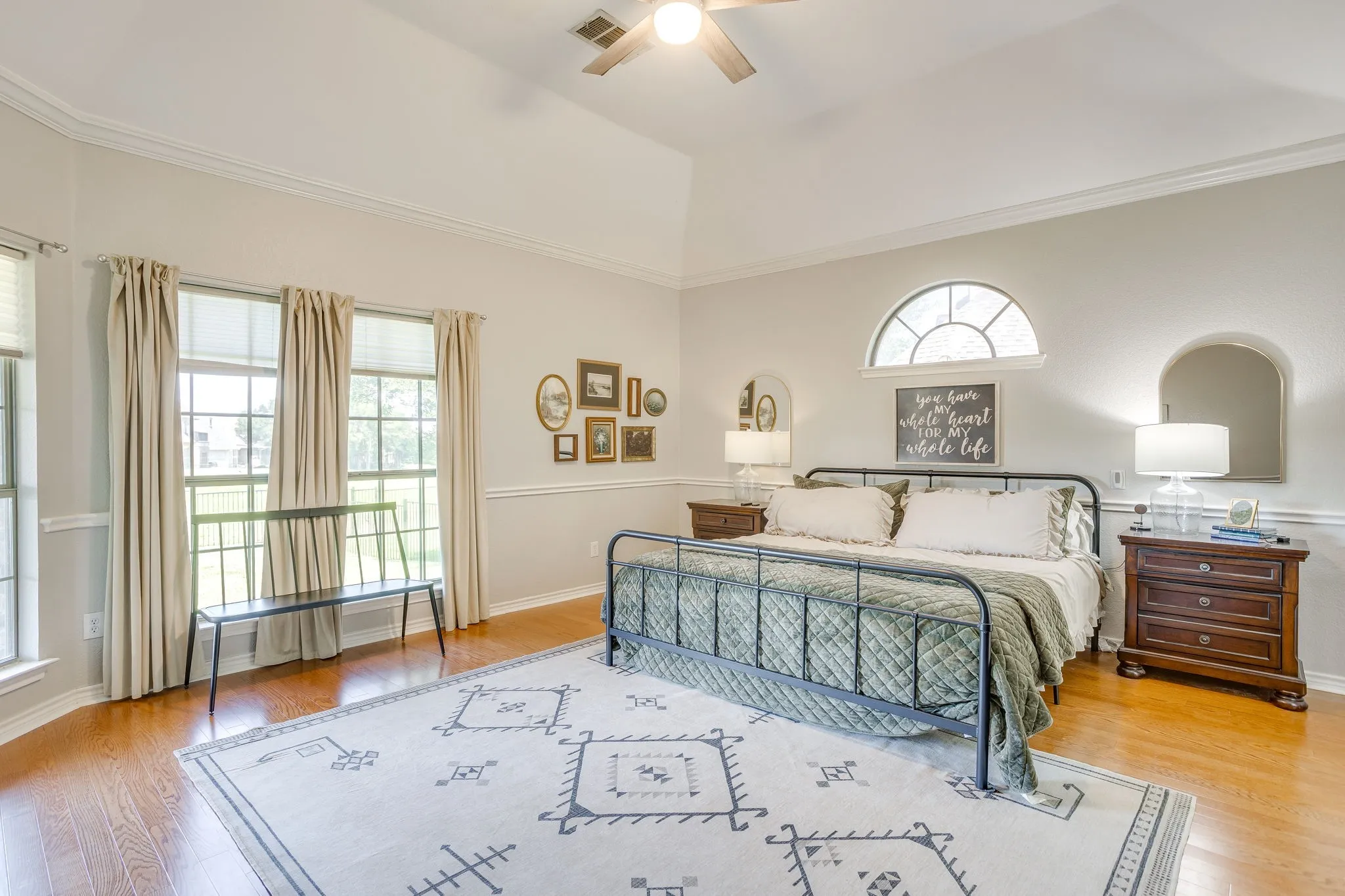 Spacious room featuring vaulted ceilings, wood-finish flooring, and multiple windows