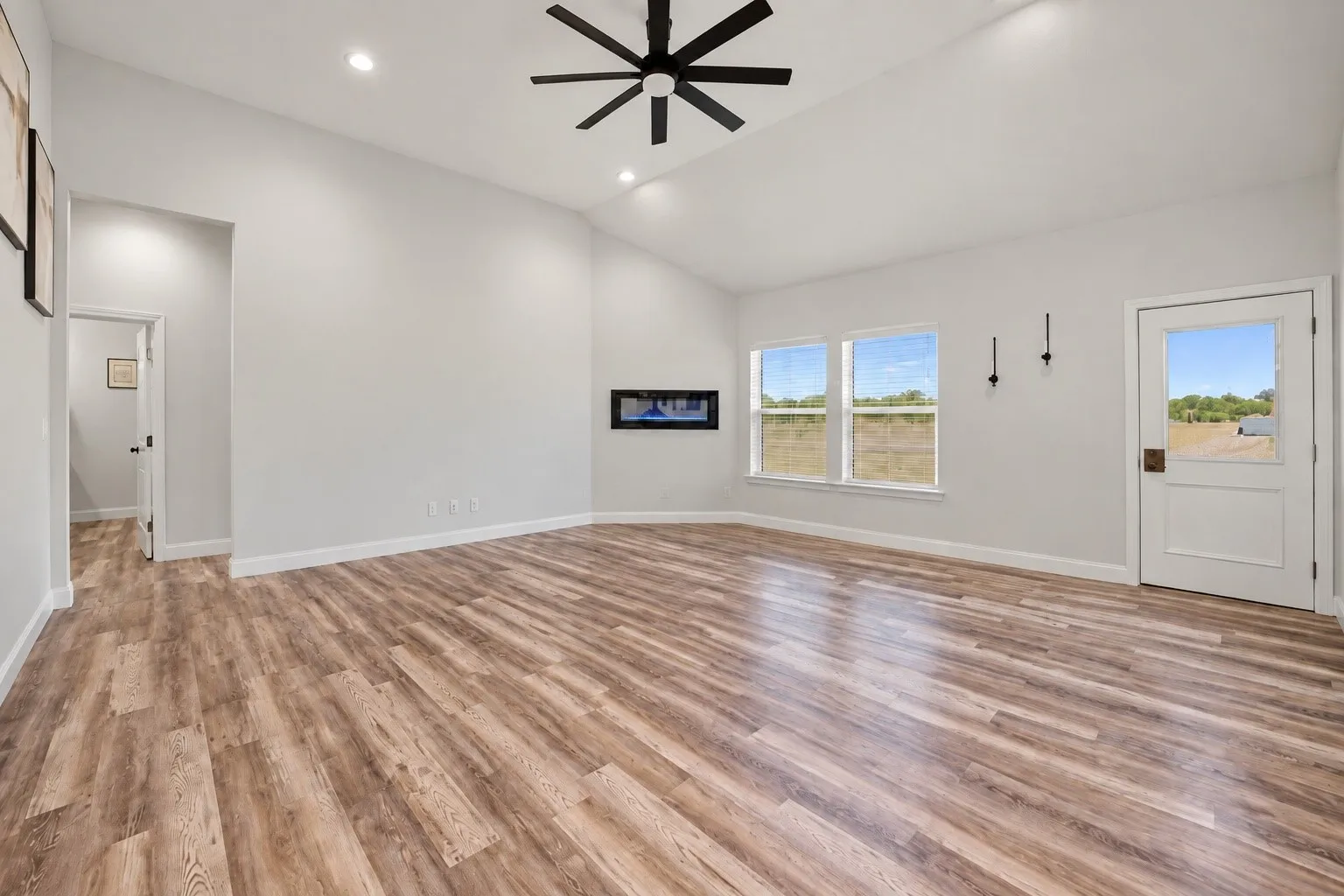 Vaulted ceilings, wood-finish flooring, recessed lighting, and a contemporary ceiling fan