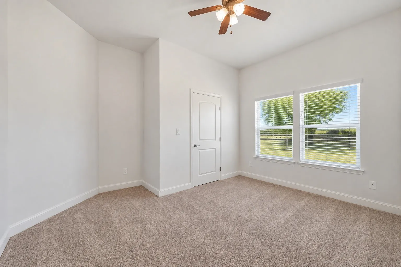 Neutral-toned carpeting, white walls, and a ceiling fan with integrated lighting