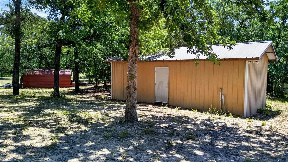 Workshop with electric featuring vertical panel siding, a single entry door, and a metal roof
