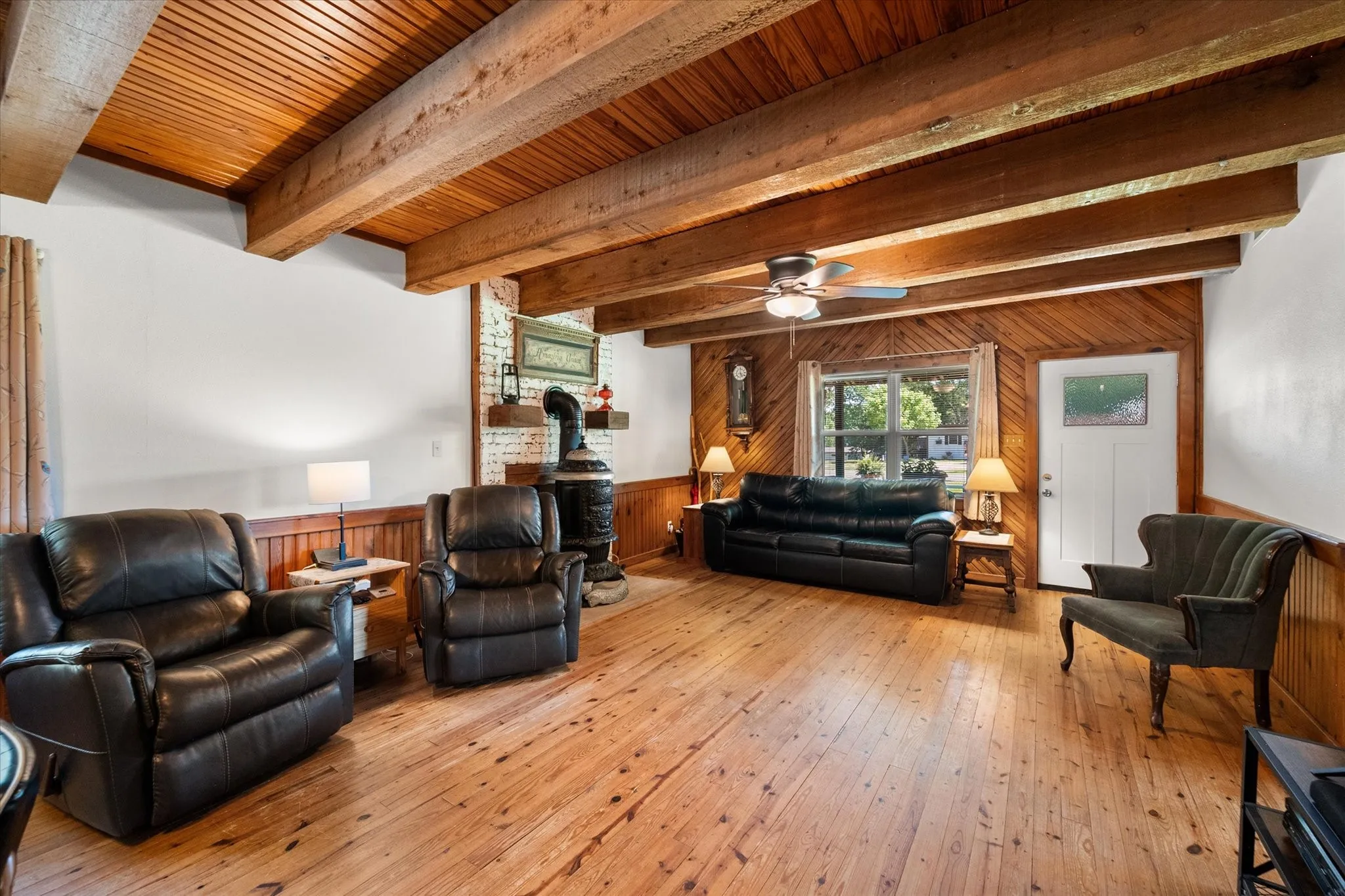 Warm, inviting living room with vaulted wood ceilings, exposed beams, and abundant natural light.