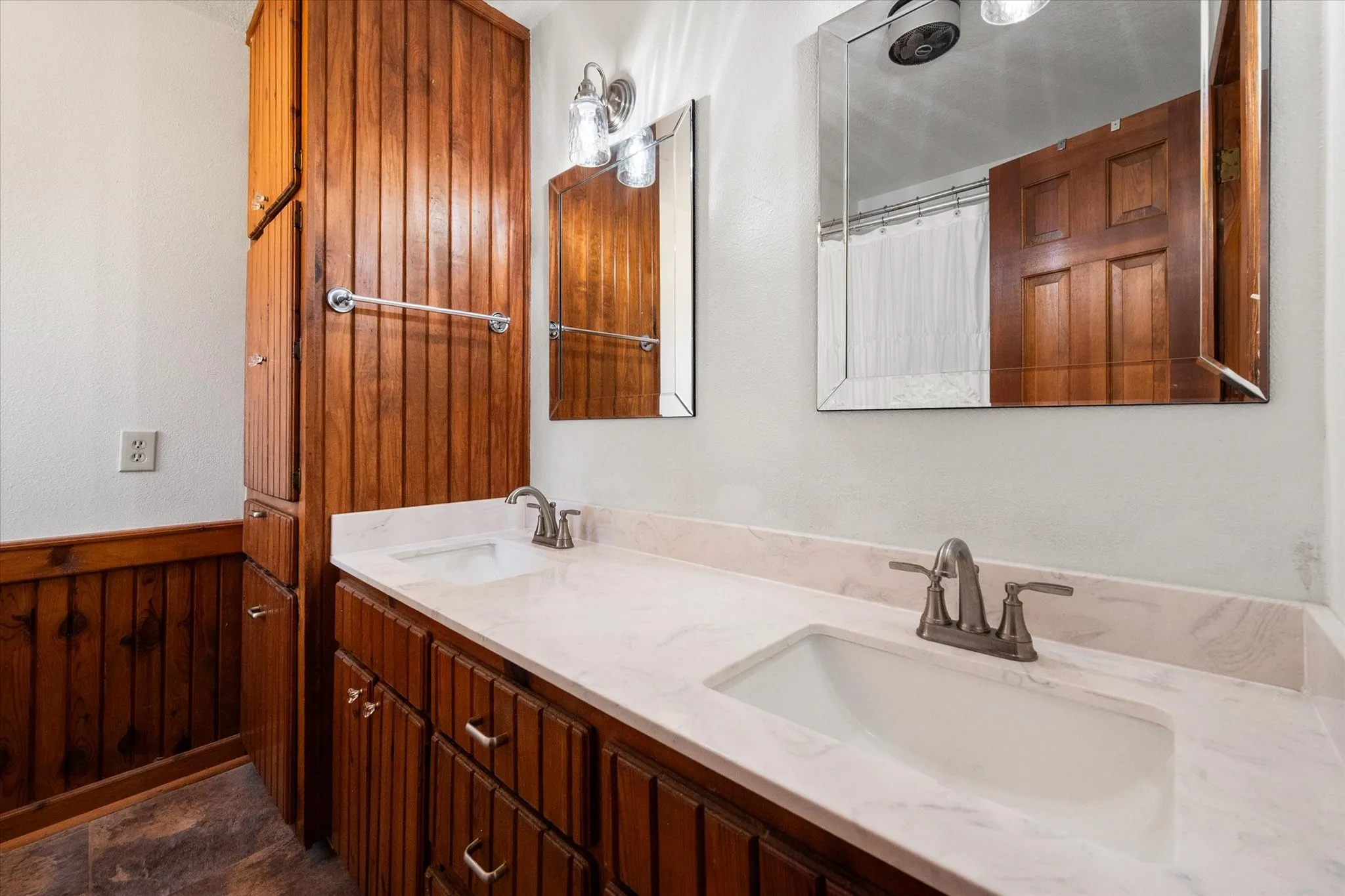 Updated primary bathroom with granite vanity and modern fixtures.