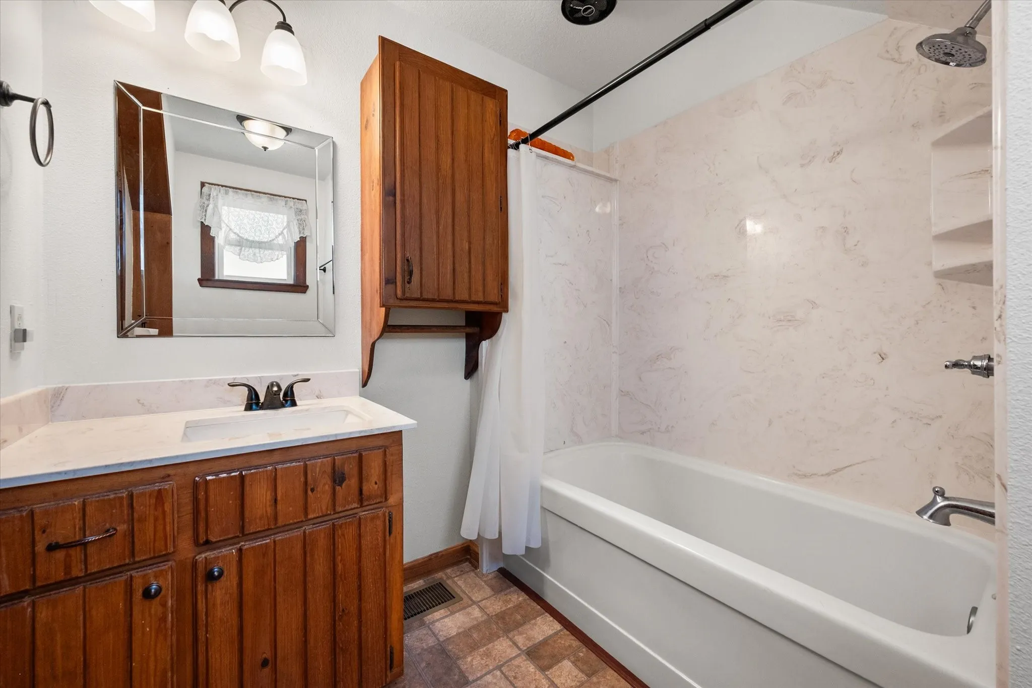 Full upstairs bathroom with updated vanity and tub-shower combination.