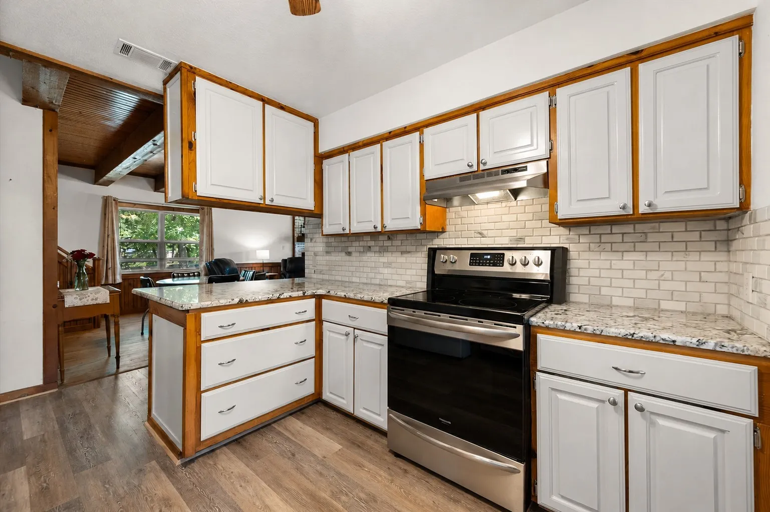 Additional kitchen view showcasing extensive cabinetry and granite countertops.
